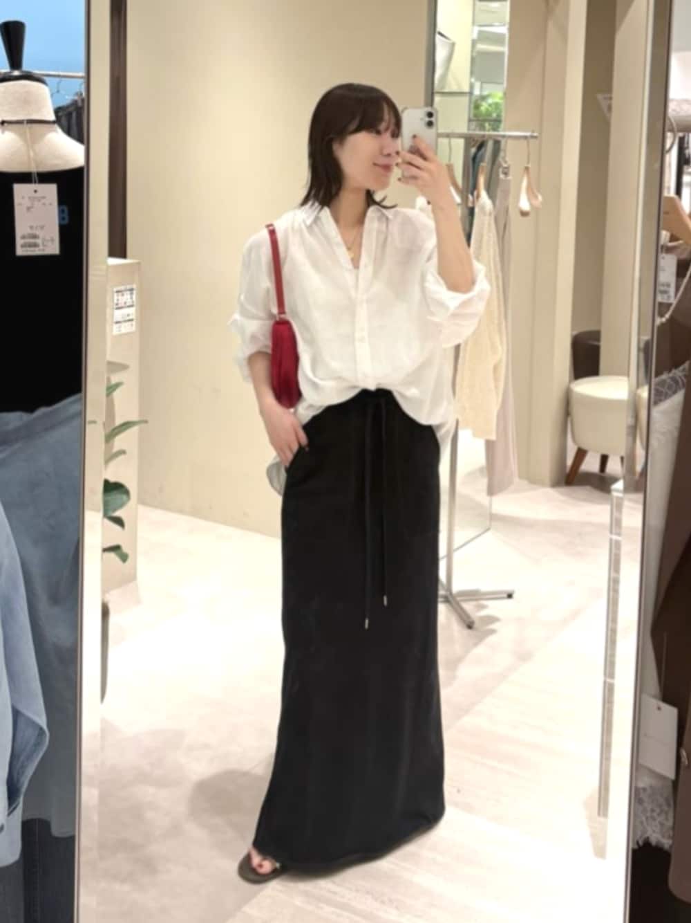 ホワイト系のシャツ/ブラウス、レッド系のハンドバッグ、ブラック系のスカートを着用したレディースの夏コーディネートの1枚目の写真