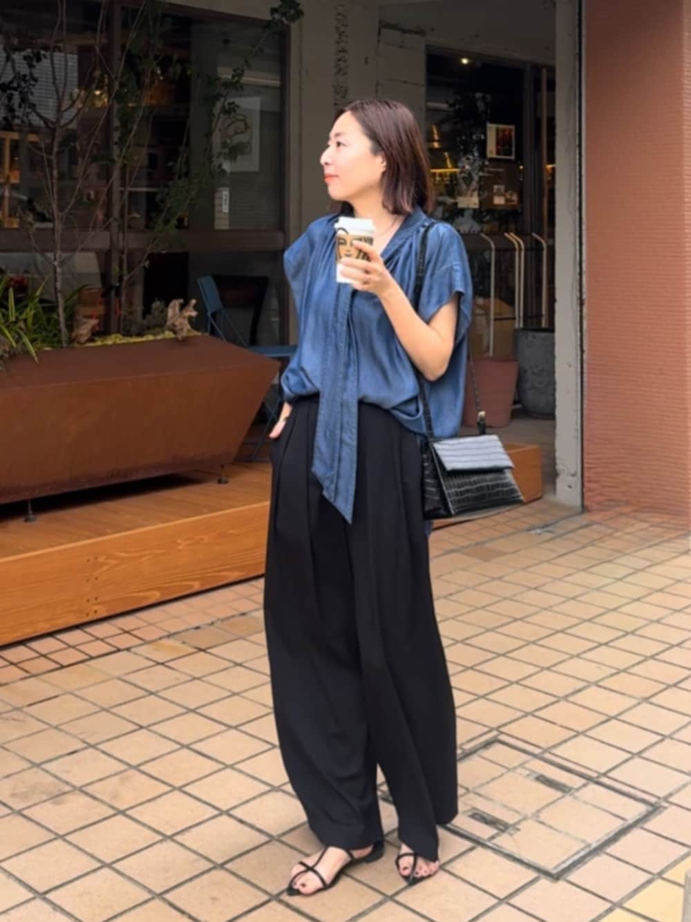 ブラック系のサンダル、ブルー系のシャツ/ブラウス、ブラック系のスラックスを着用したレディースの夏コーディネートの1枚目の写真