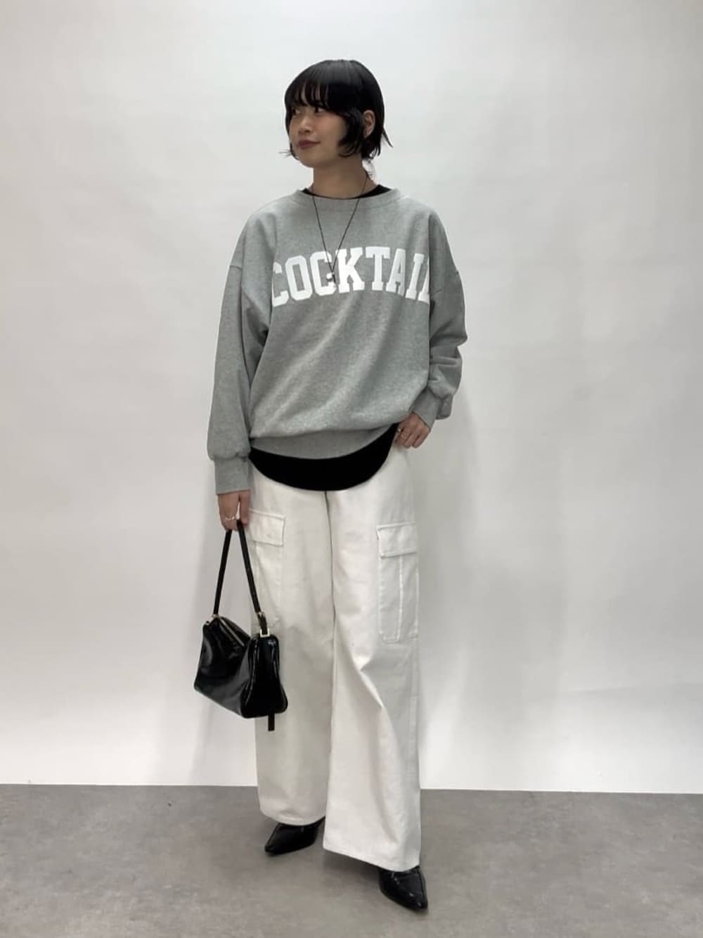 ホワイト系のカーゴパンツ、ブラック系のショルダーバッグ、ブラック系のローファーを着用したレディースの冬コーディネートの1枚目の写真