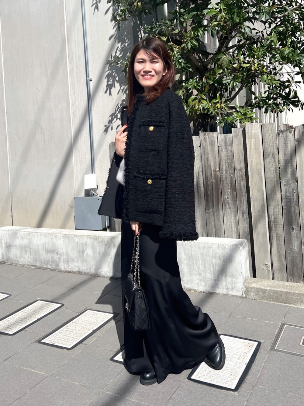ブラック系のその他アウター、ブラック系のショルダーバッグ、グレー系のニット/セーターを着用したレディースの冬コーディネートの1枚目の写真