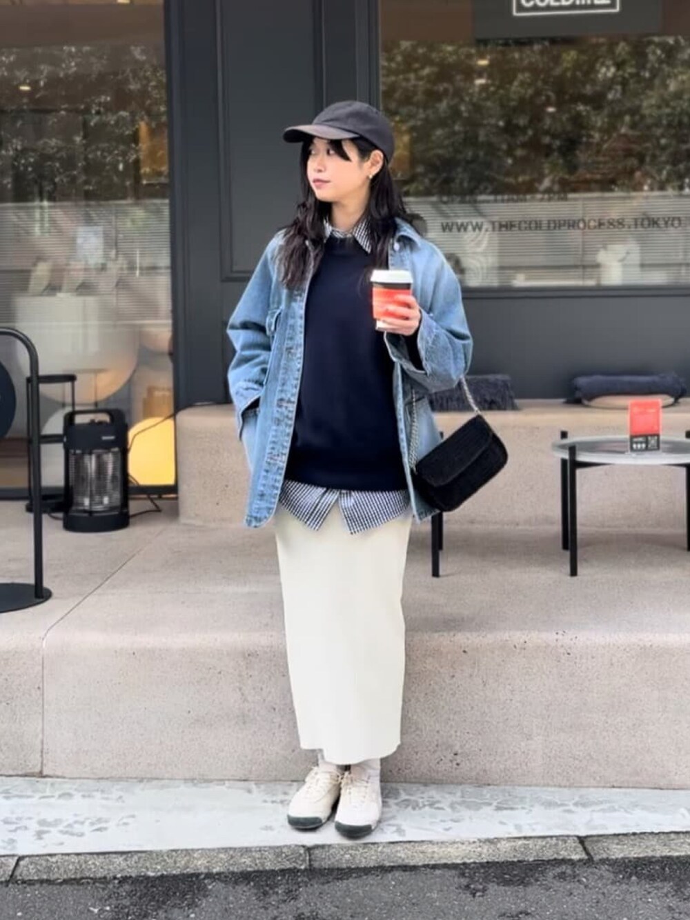 ブルー系のニット/セーター、ブラック系のシャツ/ブラウス、ブルー系のデニムジャケットを着用したレディースの春コーディネートの1枚目の写真