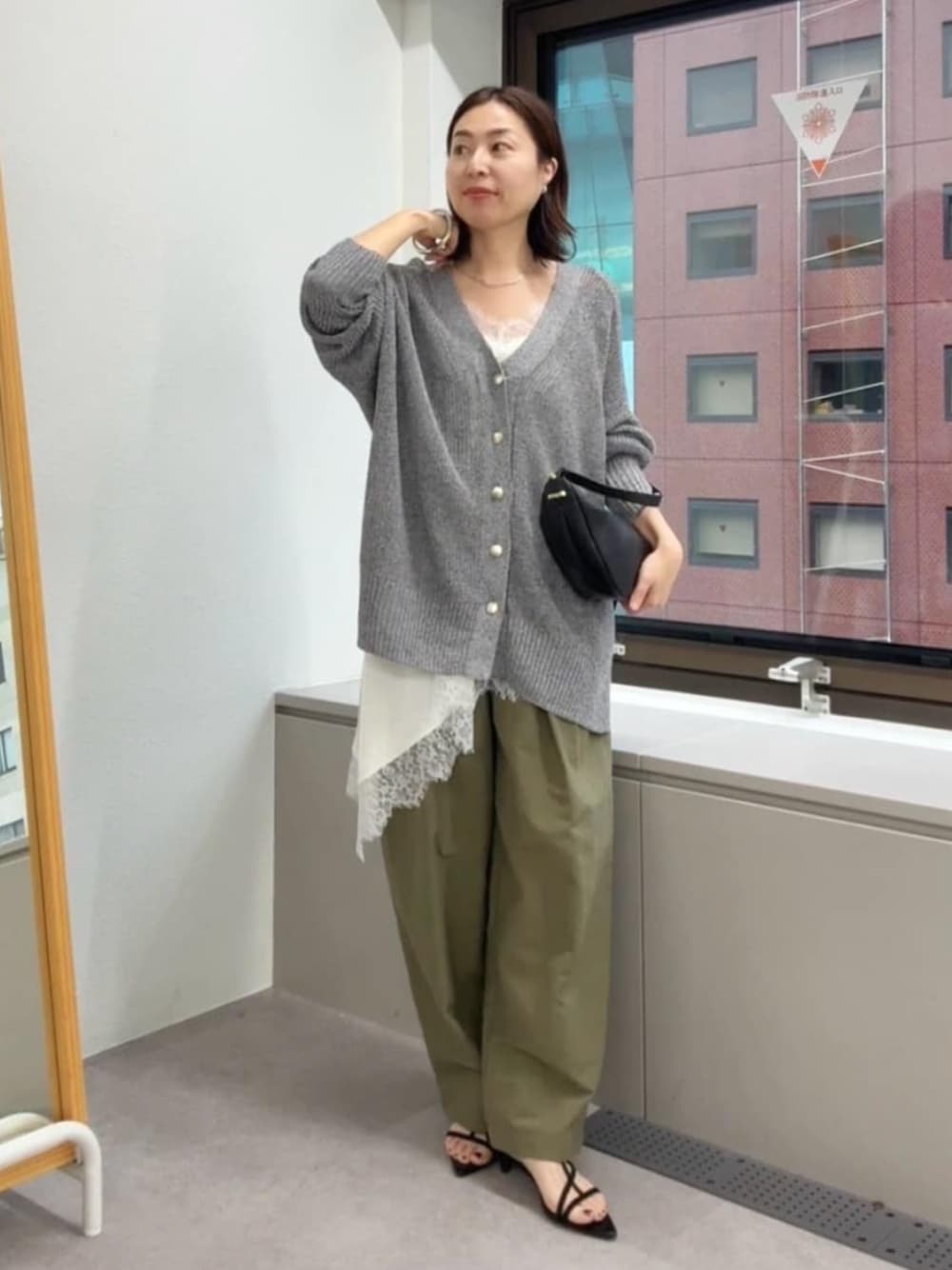 ブラック系のサンダル、ホワイト系のキャミソール、ブラック系のショルダーバッグを着用したレディースの春コーディネートの1枚目の写真