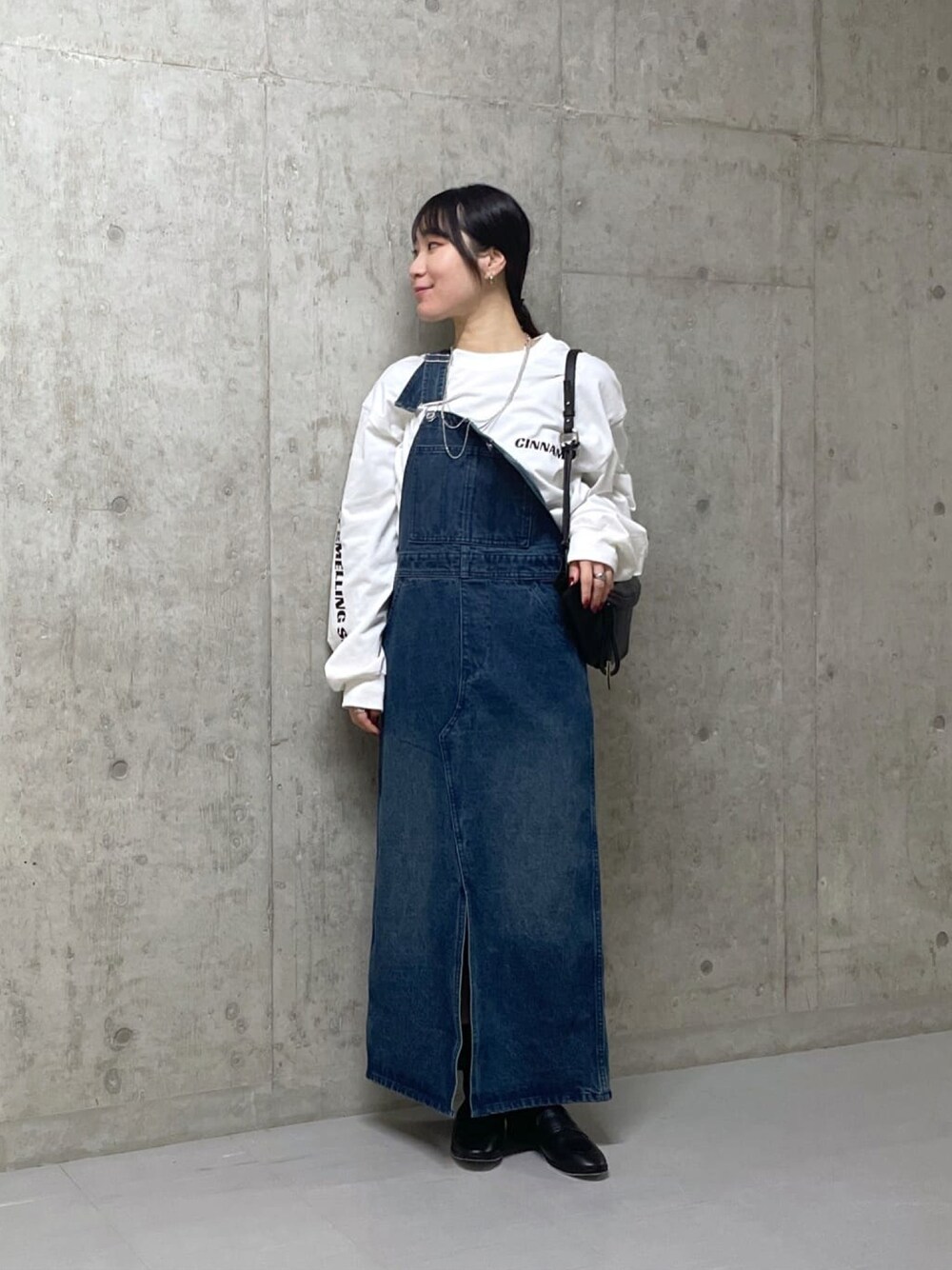 ホワイト系のTシャツ/カットソー、ブルー系のジャンパースカートを着用したレディースの冬コーディネートの1枚目の写真