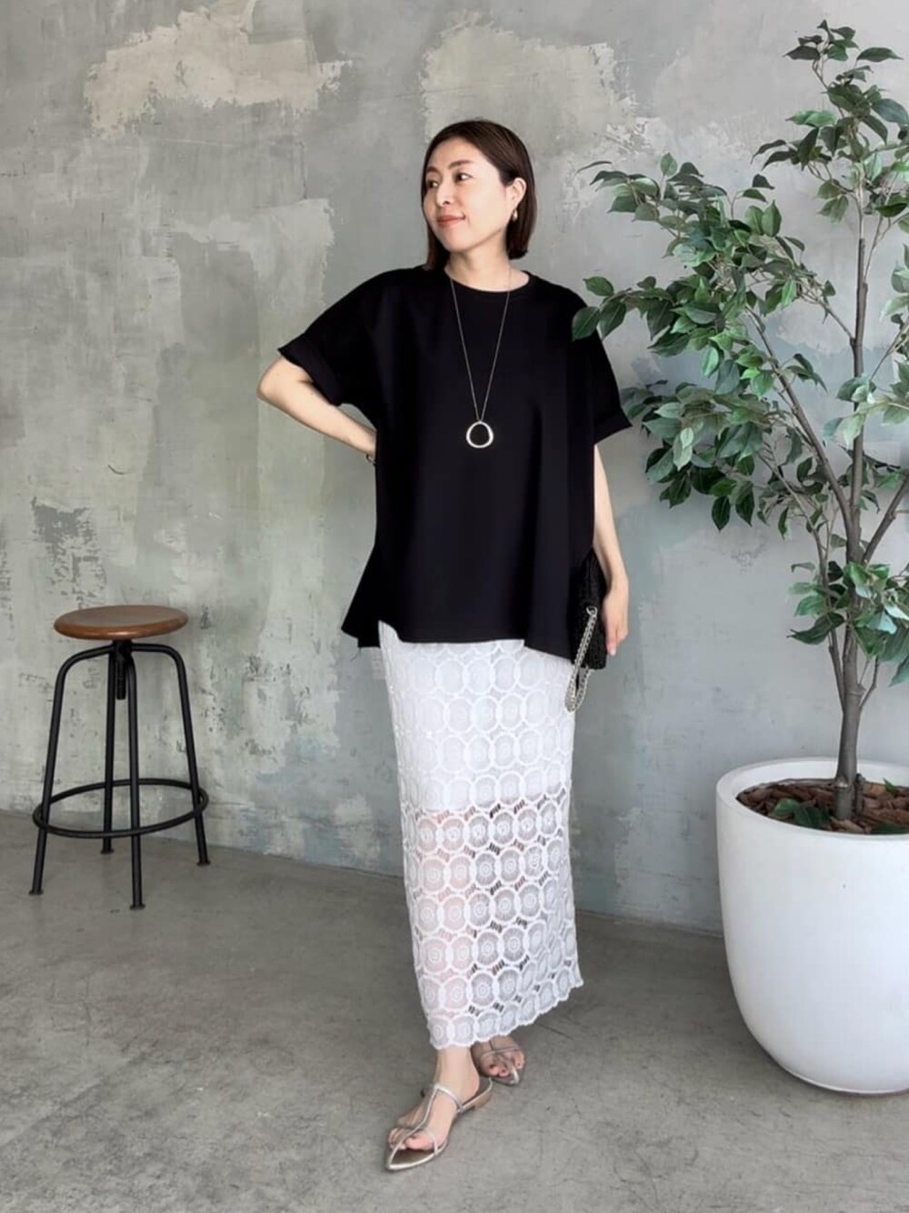 ブラック系のTシャツ/カットソー、ブラック系のショルダーバッグ、ホワイト系のスカートを着用したレディースの夏コーディネートの1枚目の写真