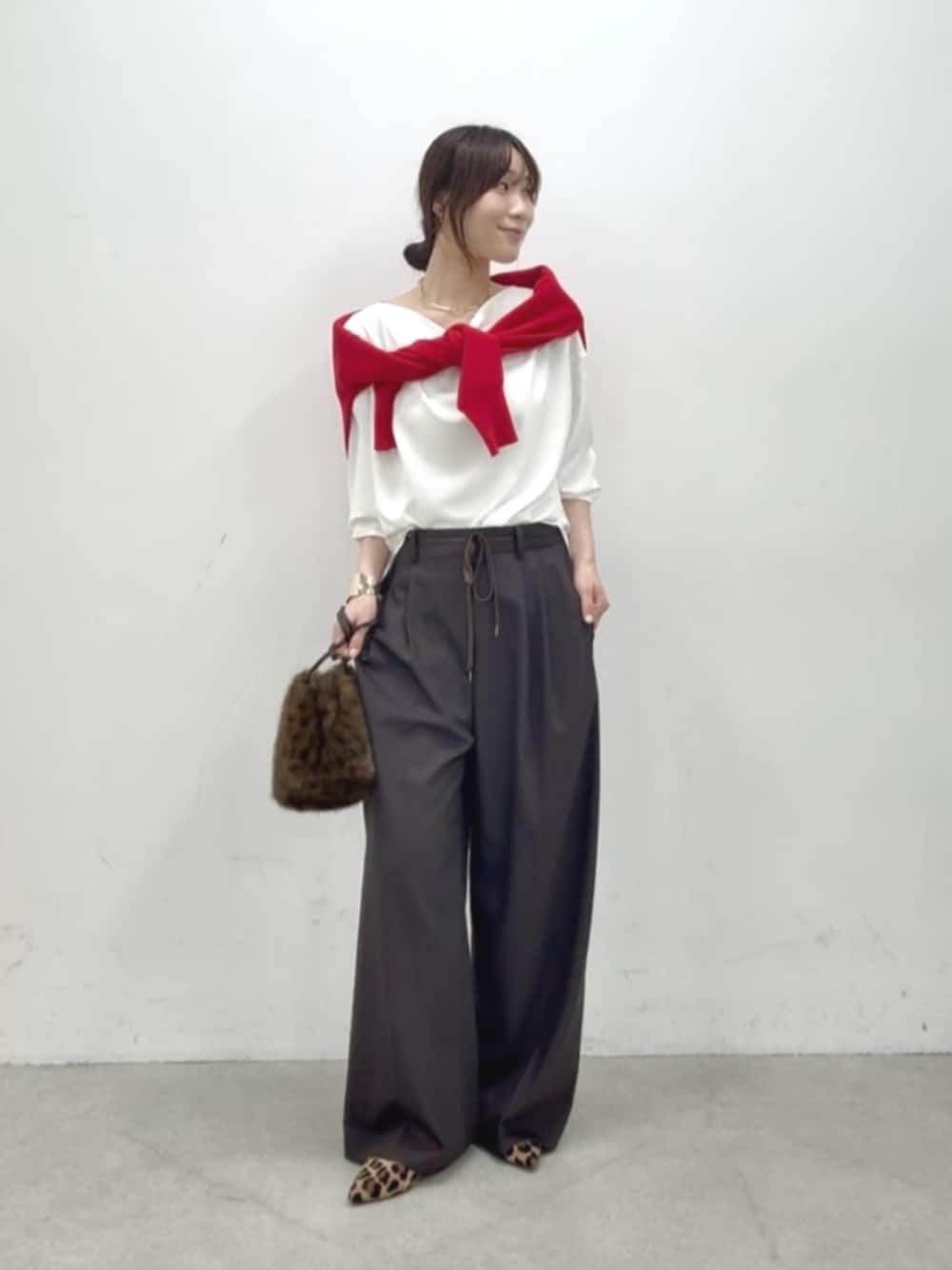 ベージュ系のパンプス、ブラウン系のハンドバッグ、ブラウン系のスラックスを着用したレディースの秋コーディネートの1枚目の写真