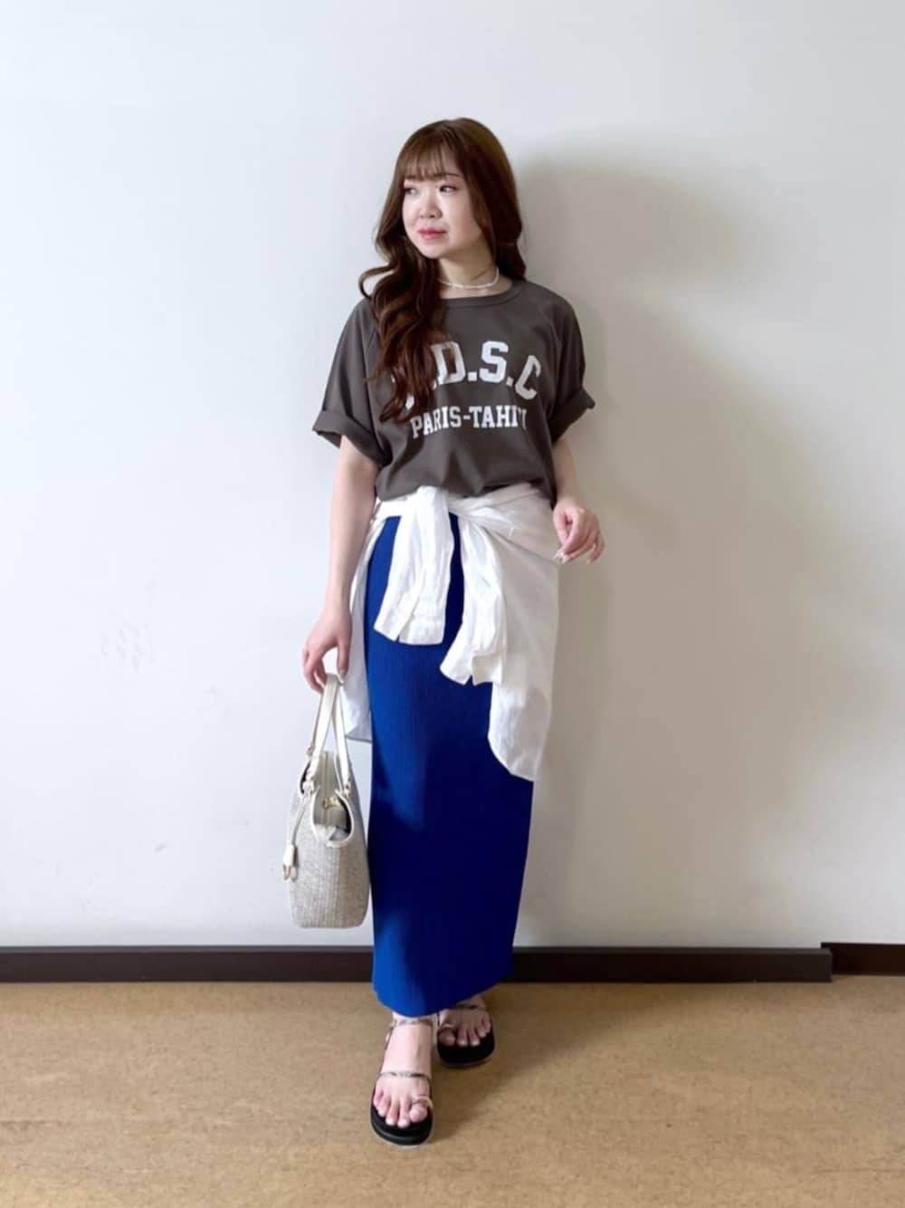 ブラウン系のTシャツ/カットソー、ホワイト系のハンドバッグ、ベージュ系のサンダルを着用したレディースの夏コーディネートの1枚目の写真
