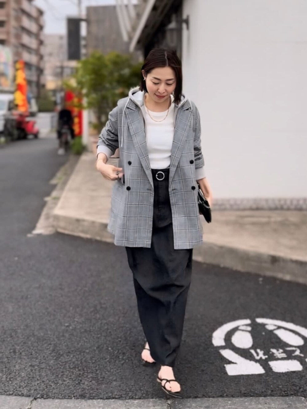 グレー系のテーラードジャケット、ブルー系のデニムスカート、ベージュ系のパーカーを着用したレディースの春コーディネートの1枚目の写真