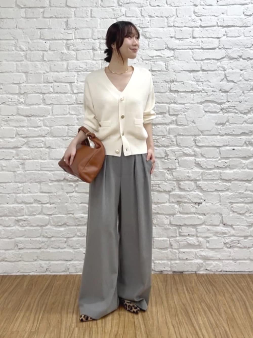 ベージュ系のパンプス、ホワイト系のカーディガン/ボレロ、ゴールド系のチョーカーを着用したレディースの秋コーディネートの1枚目の写真