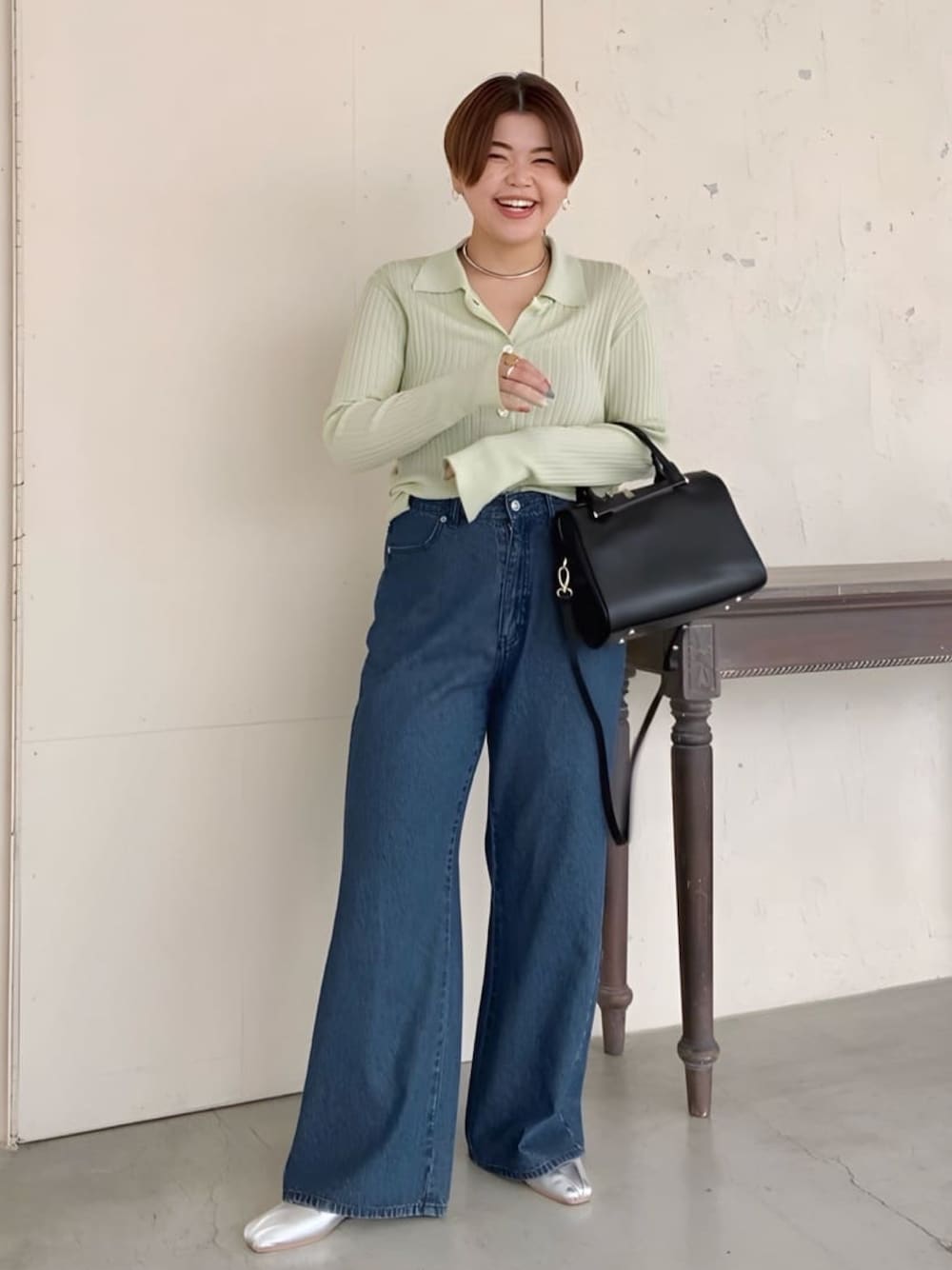 グリーン系のカーディガン/ボレロ、ブルー系のデニムパンツ、シルバー系のパンプスを着用したレディースの夏コーディネートの1枚目の写真