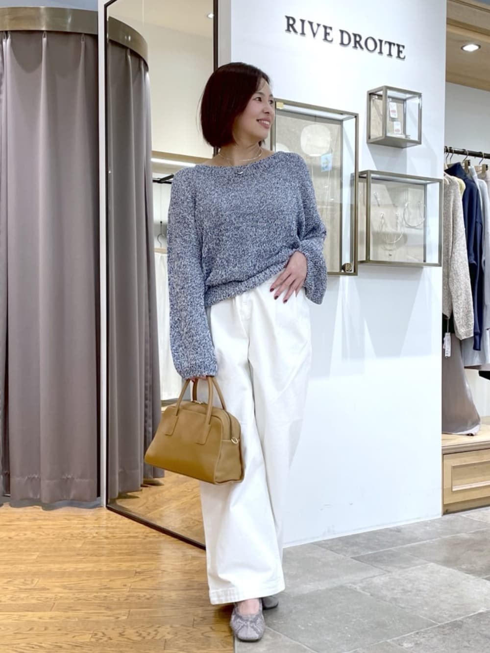 イエロー系のボストンバッグ、ホワイト系のデニムパンツ、ブルー系のニット/セーターを着用したレディースの春コーディネートの1枚目の写真