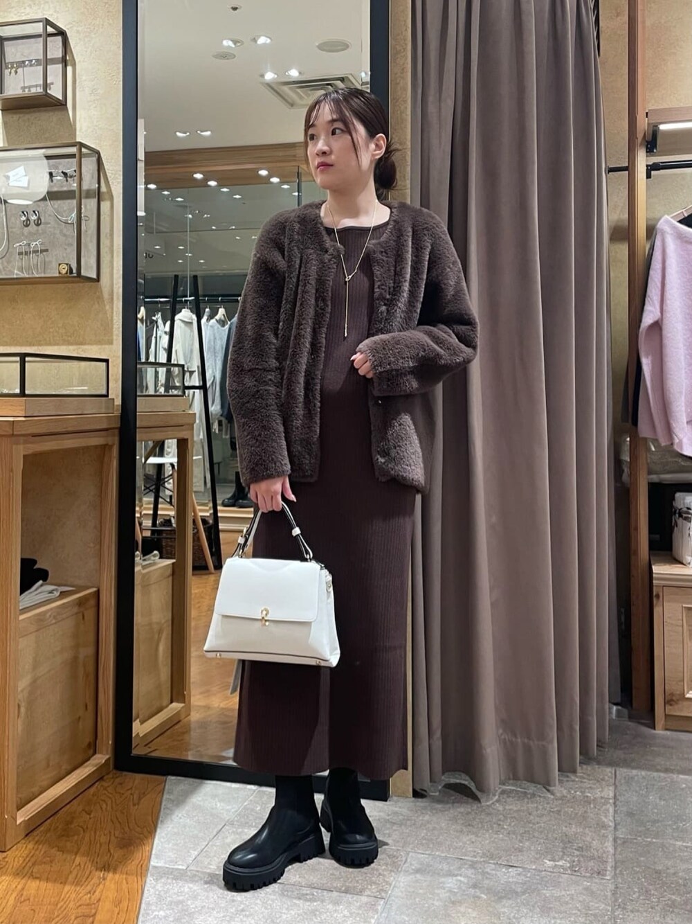 ブラウン系のカーディガン/ボレロ、ブラウン系のワンピース、ブラック系のブーツを着用したレディースの秋コーディネートの1枚目の写真