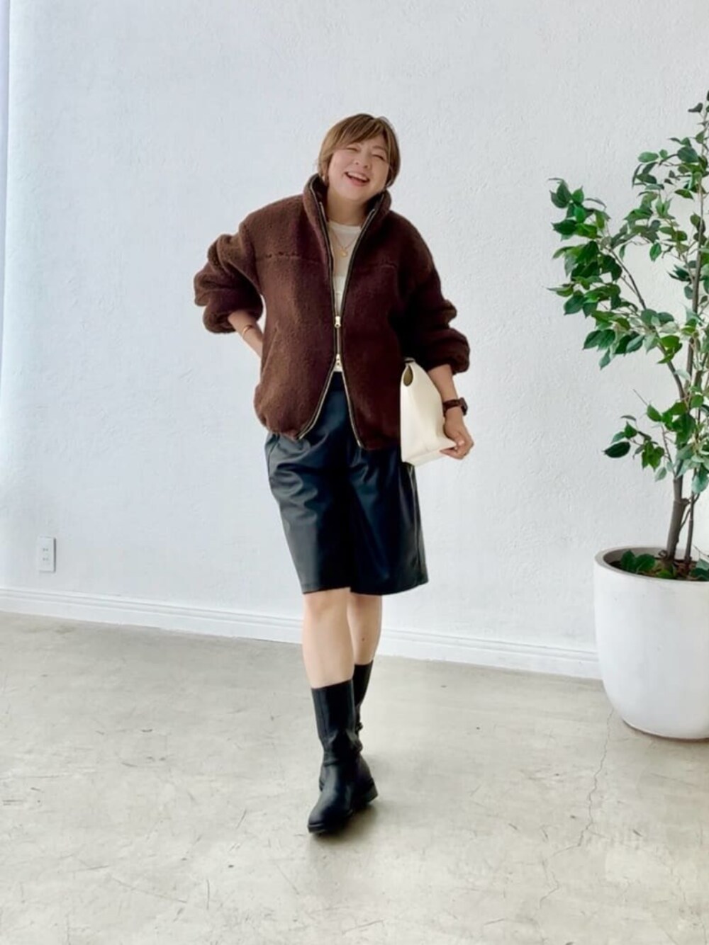 ブラック系のブーツ、ブラック系のその他パンツ、ホワイト系のTシャツ/カットソーを着用したレディースの秋コーディネートの1枚目の写真