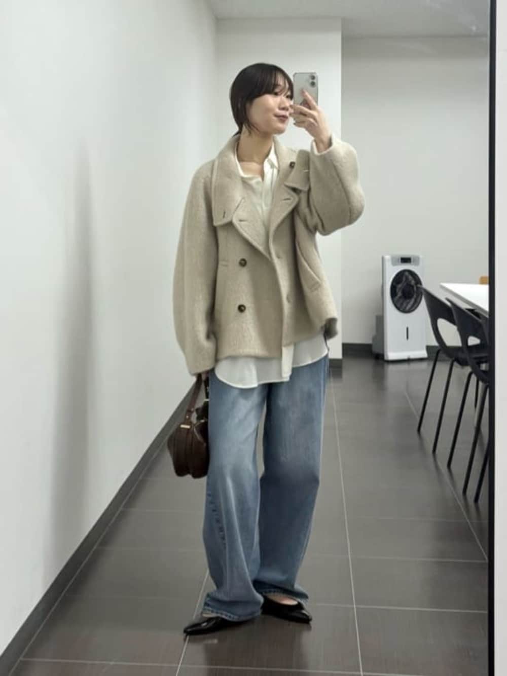 ブラウン系のショルダーバッグ、ブルー系のデニムパンツ、ホワイト系のキャミソールを着用したレディースの夏コーディネートの1枚目の写真