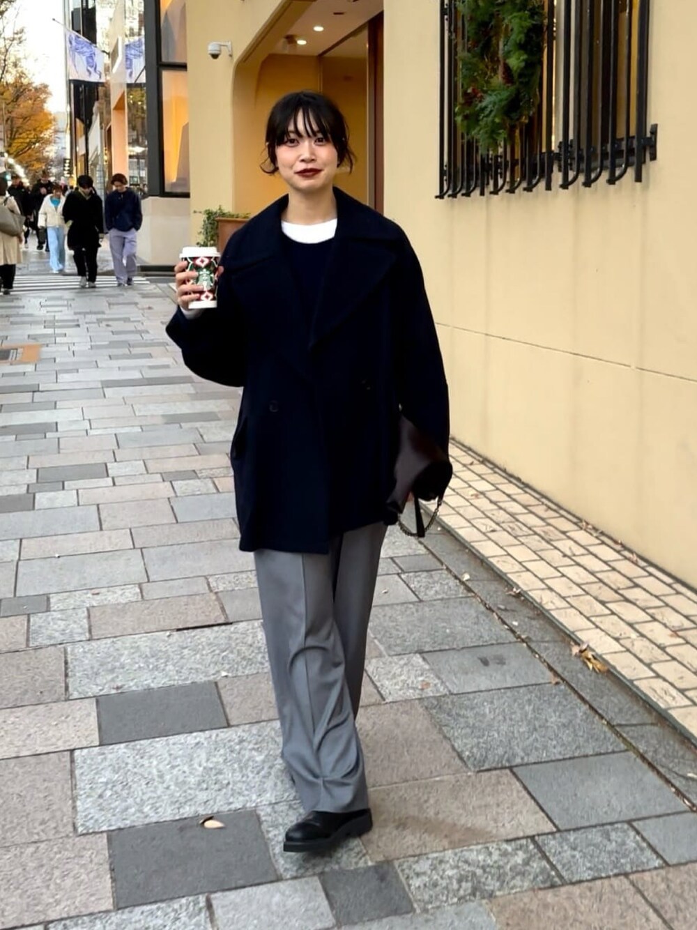 ブルー系のピーコート、グレー系のその他パンツ、ブラック系のブーツを着用したレディースの冬コーディネートの1枚目の写真