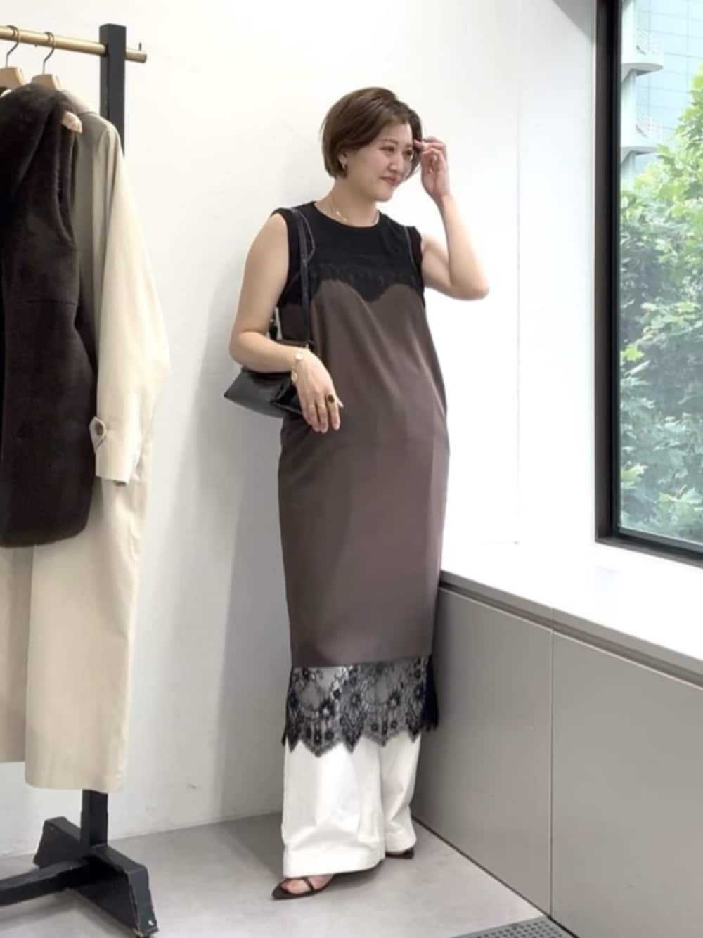 ホワイト系のデニムパンツ、ブラウン系のワンピース、ブラック系のキャミソールを着用したレディースの夏コーディネートの1枚目の写真
