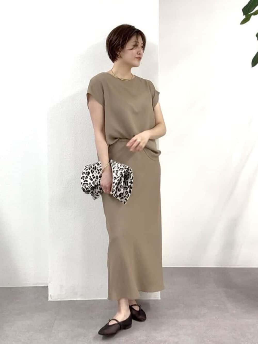 ブラック系のその他シューズ、ベージュ系のトートバッグ、ブラウン系のシャツ/ブラウスを着用したレディースの春コーディネートの1枚目の写真