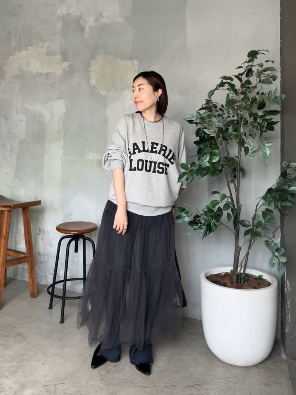 グレー系のスウェット、グレー系のスカートを着用したレディースの夏コーディネートの1枚目の写真