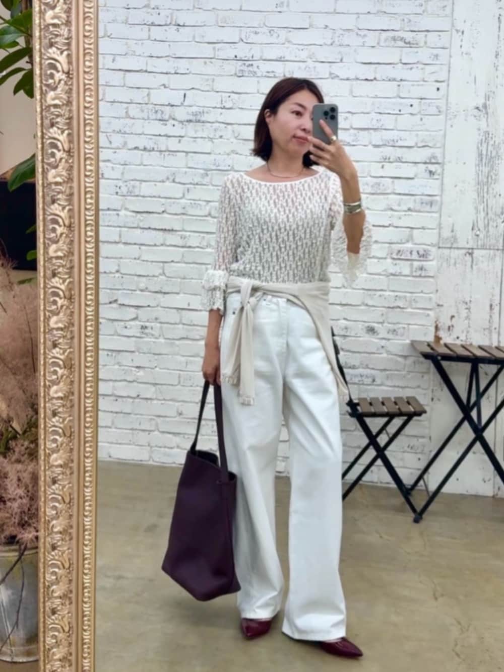 レッド系のパンプス、ホワイト系のデニムパンツ、ホワイト系のTシャツ/カットソーを着用したレディースの夏コーディネートの1枚目の写真