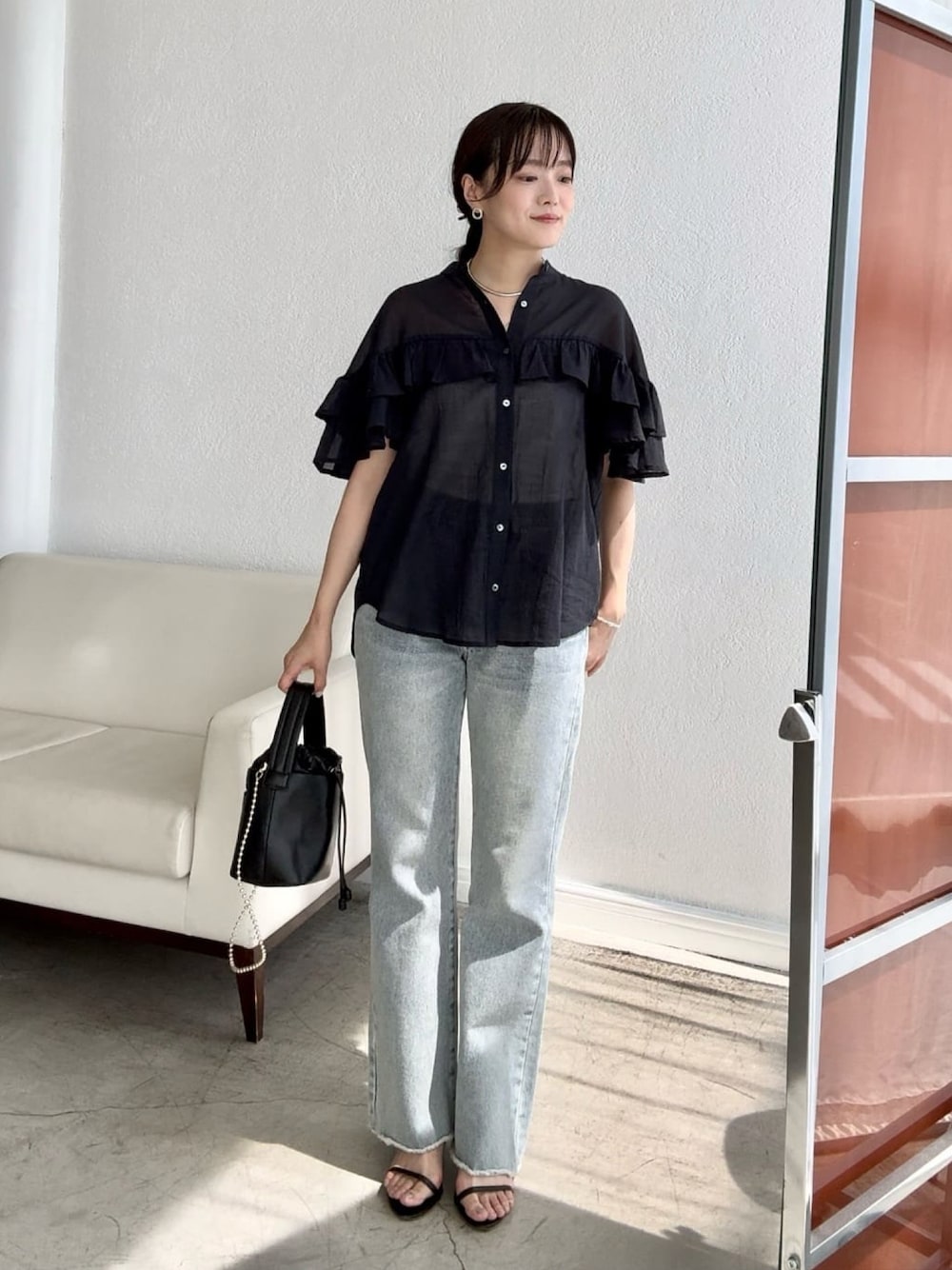 ブラック系のシャツ/ブラウス、ブルー系のデニムパンツ、ブラック系のサンダルを着用したレディースの夏コーディネートの1枚目の写真