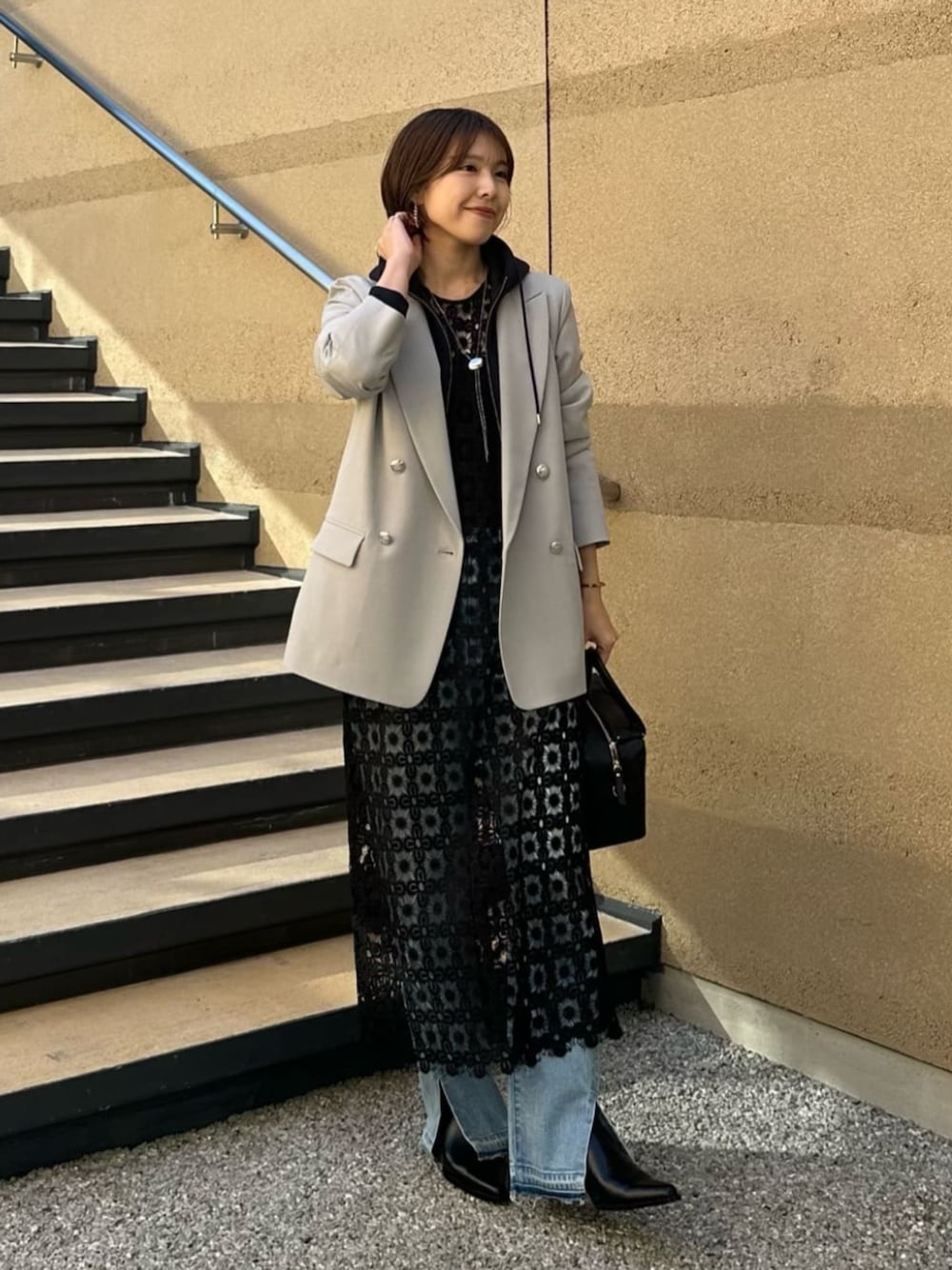 ブルー系のパーカー、ブラック系のボストンバッグ、ブルー系のデニムパンツを着用したレディースの冬コーディネートの1枚目の写真