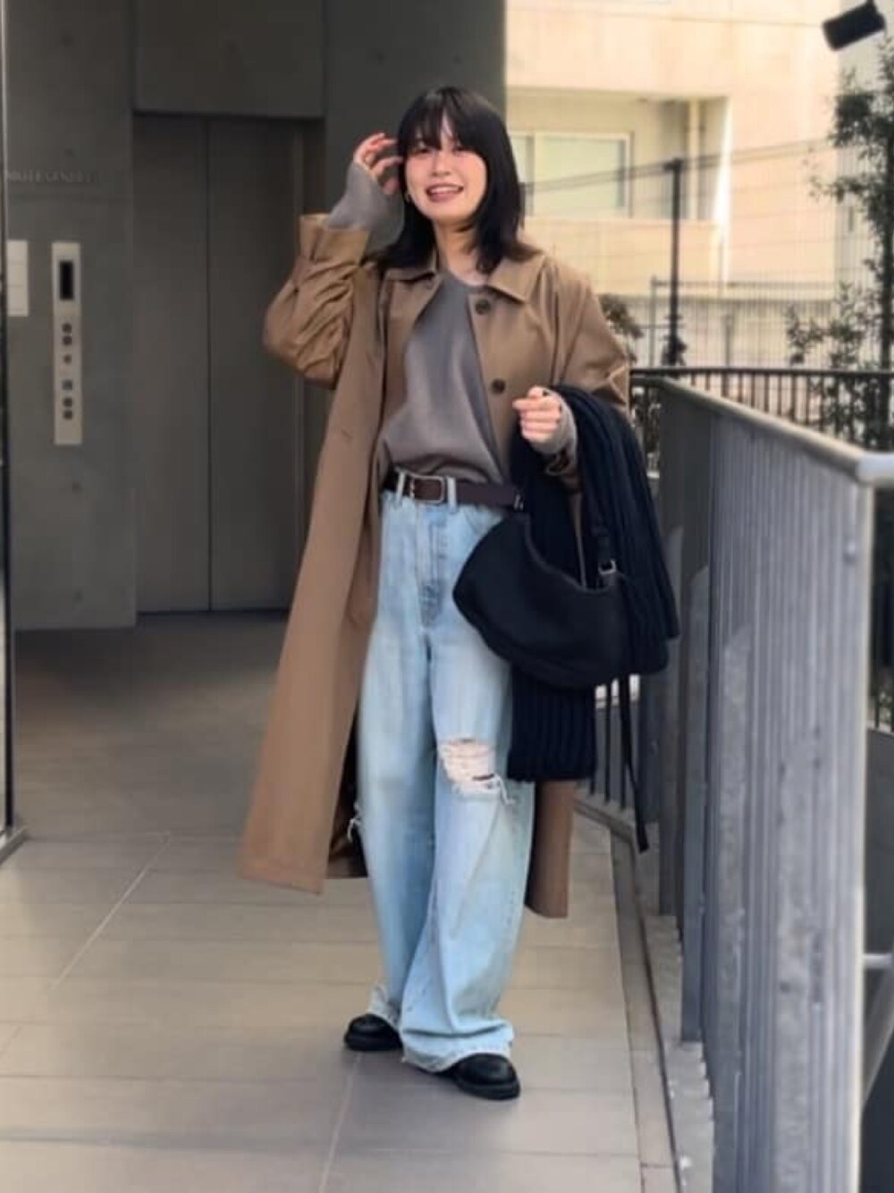 ベージュ系のニット/セーター、ブルー系のデニムパンツ、ブラウン系のステンカラーコートを着用したレディースの冬コーディネートの1枚目の写真