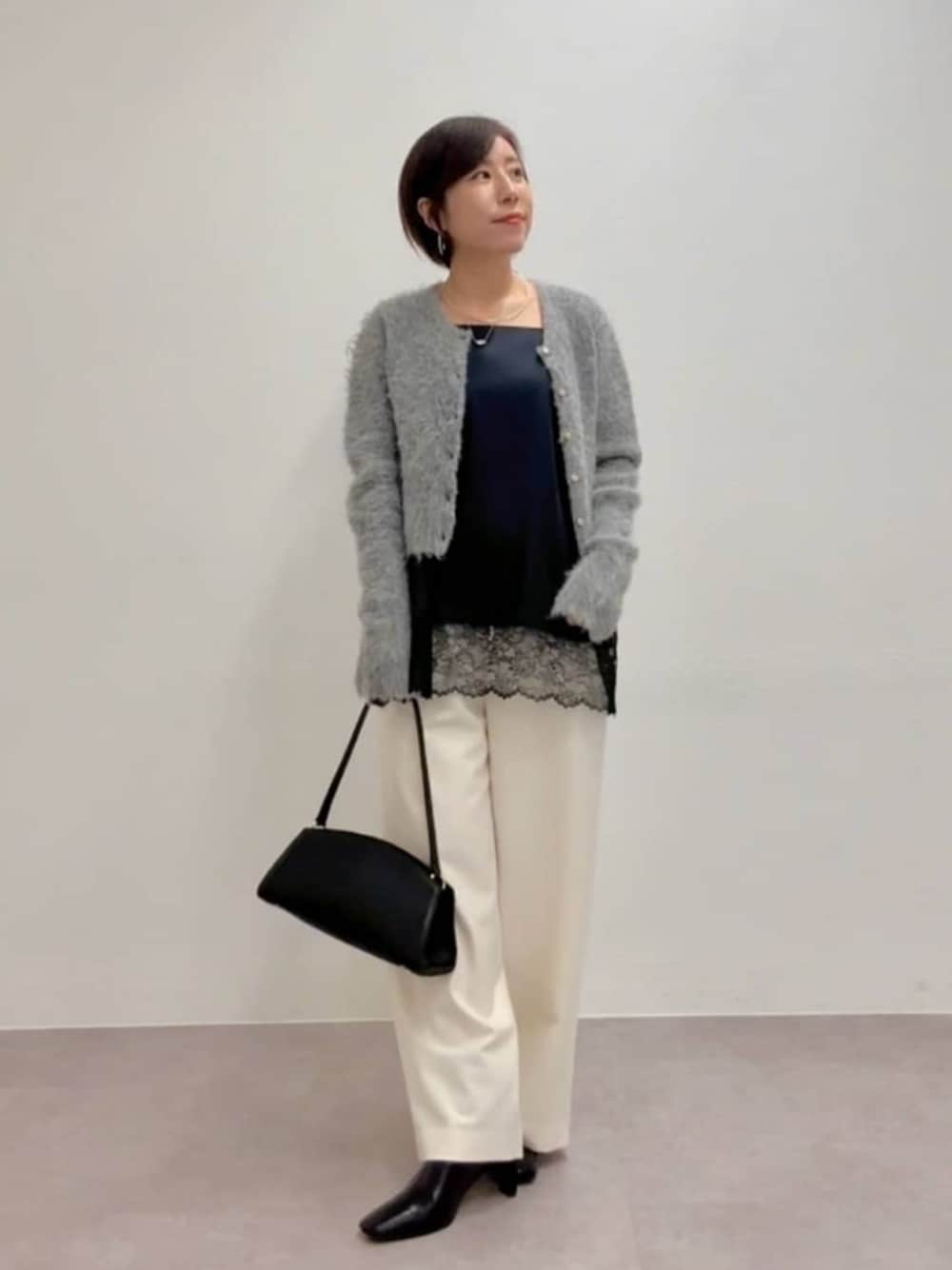 ブラック系のブーツ、ブラック系のハンドバッグ、ブラック系のキャミソールを着用したレディースの秋コーディネートの1枚目の写真