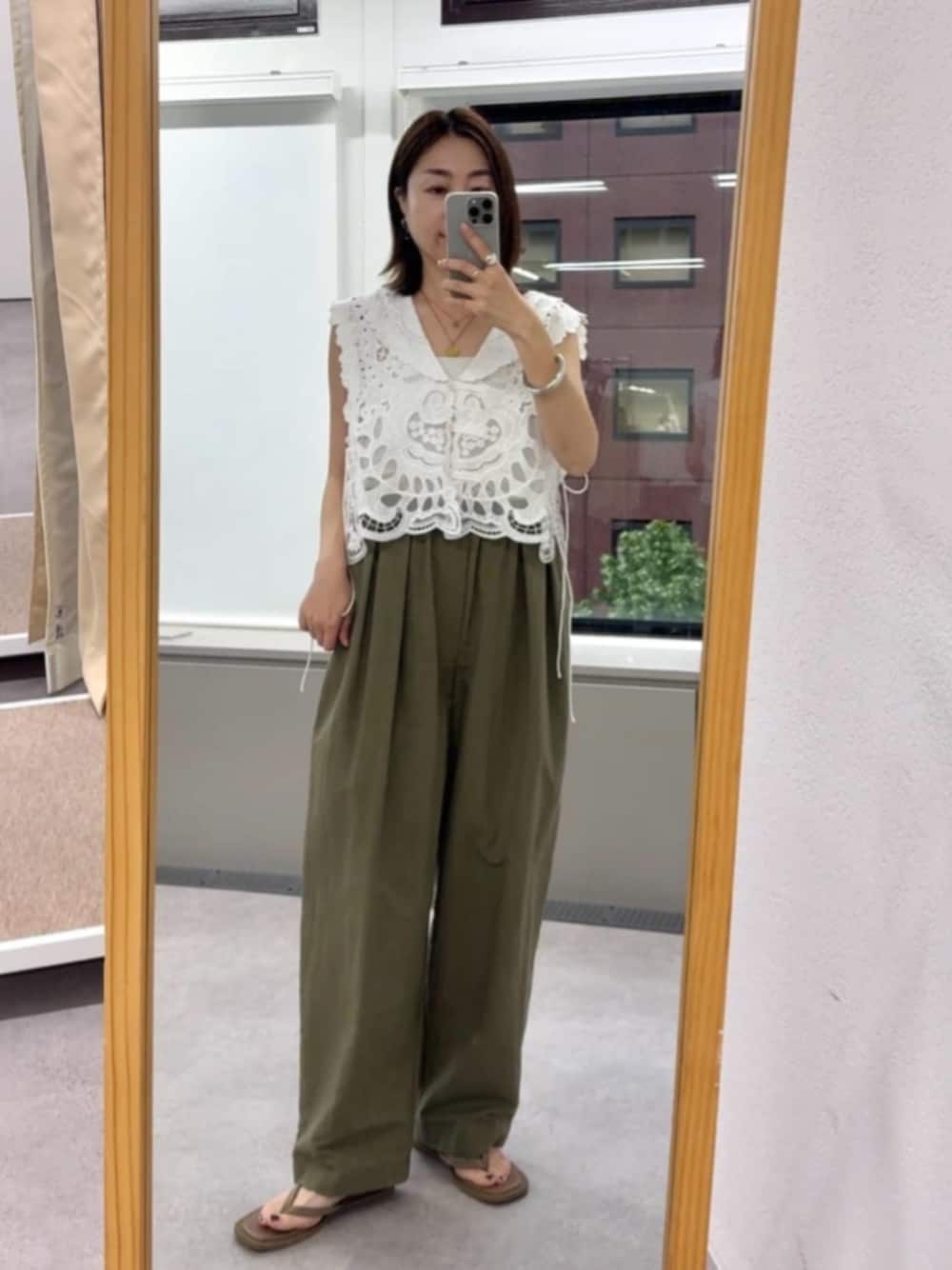 グリーン系のその他パンツ、ホワイト系のベスト、ベージュ系のサンダルを着用したレディースの夏コーディネートの1枚目の写真
