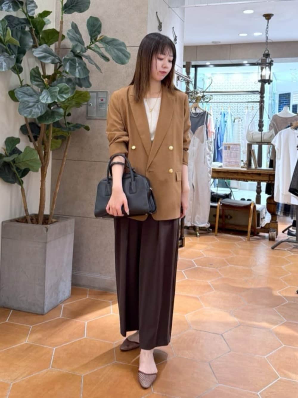 ベージュ系のTシャツ/カットソー、ブラック系のボストンバッグ、ブラウン系のテーラードジャケットを着用したレディースの夏コーディネートの1枚目の写真