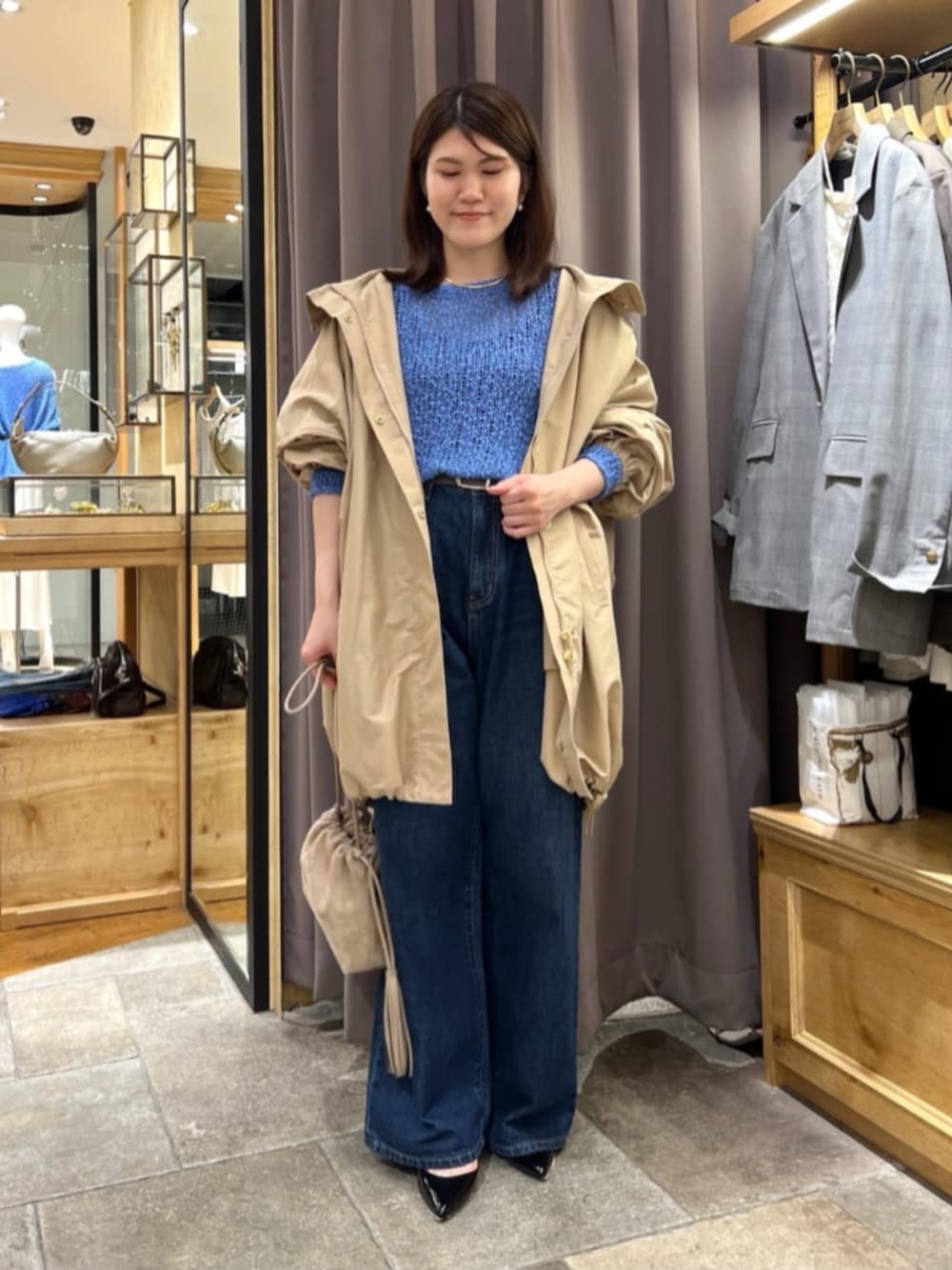 ベージュ系のショルダーバッグ、ブラック系のパンプス、ブルー系のニット/セーターを着用したレディースの秋コーディネートの1枚目の写真