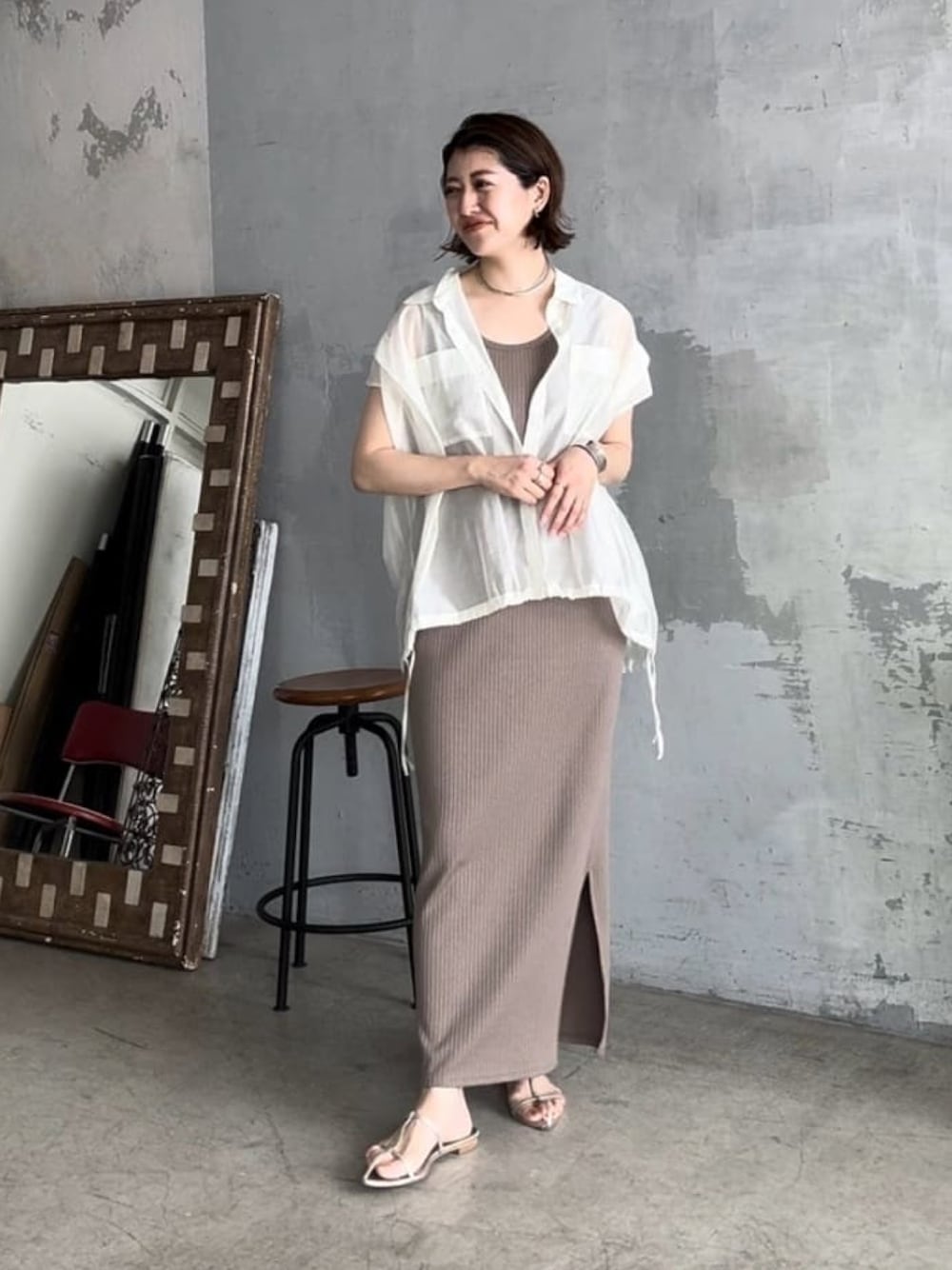 グリーン系のワンピース、シルバー系のサンダル、ホワイト系のシャツ/ブラウスを着用したレディースの春コーディネートの1枚目の写真