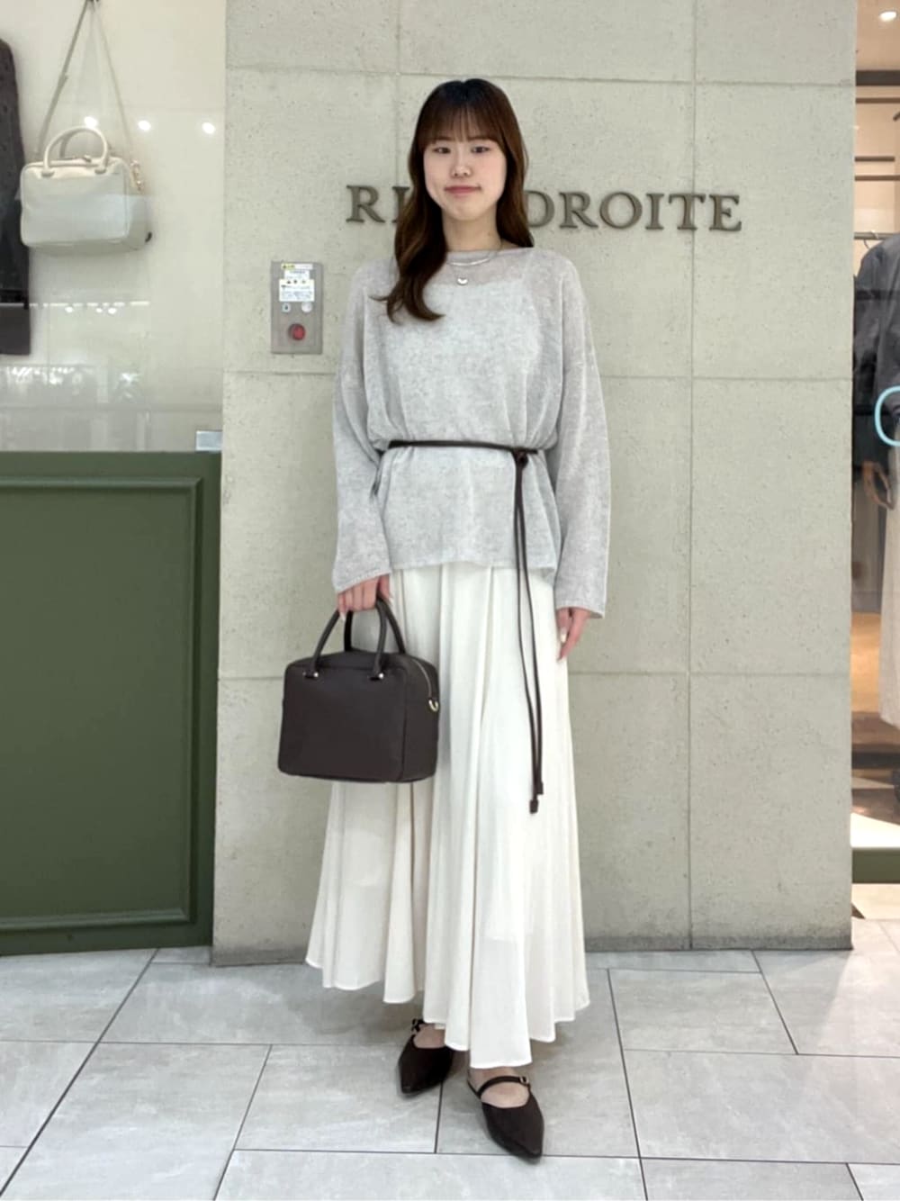 ブラウン系のその他シューズ、ブラウン系のボストンバッグ、ベージュ系のスカートを着用したレディースの春コーディネートの1枚目の写真