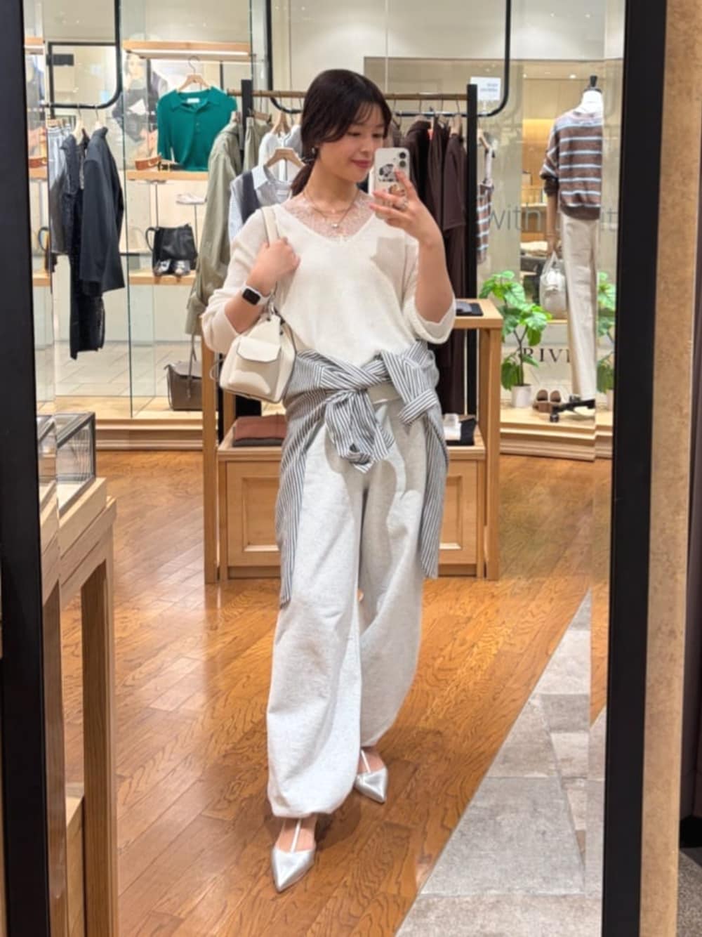 グレー系のスウェットパンツ、ホワイト系のニット/セーター、ホワイト系のショルダーバッグを着用したレディースの春コーディネートの1枚目の写真