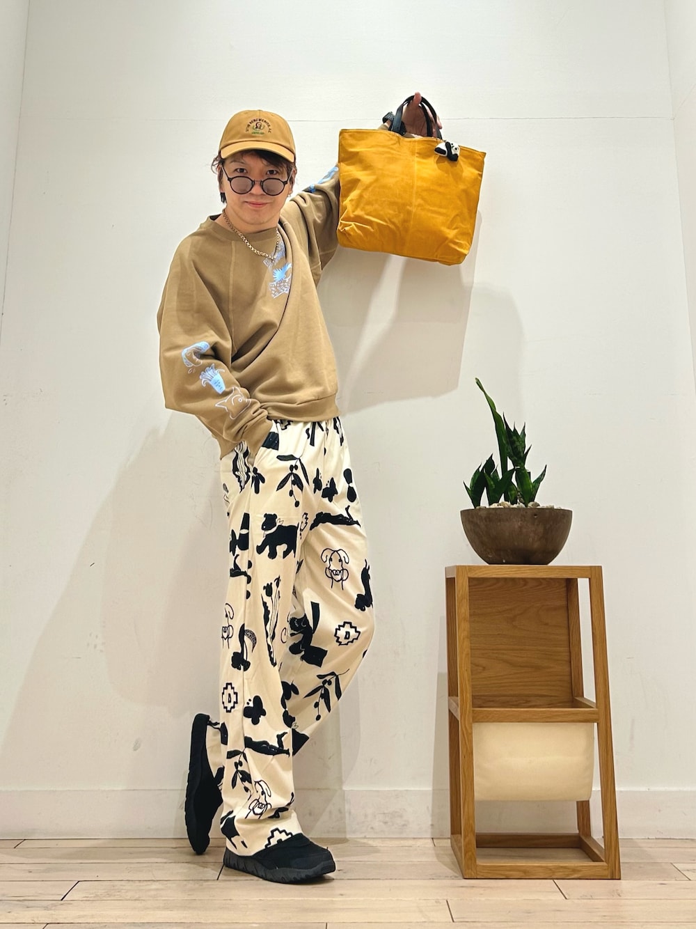 ホワイト系のその他パンツ、ブラック系のスリッポン、イエロー系のトートバッグを着用したメンズの秋コーディネートの1枚目の写真