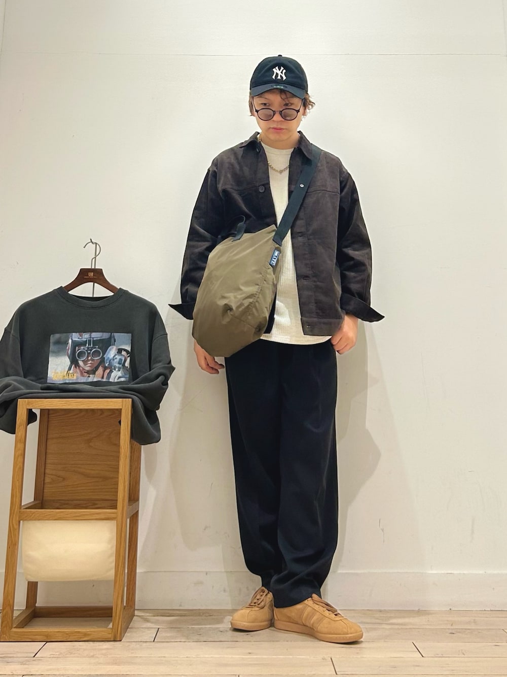 ブラウン系のその他アウター、ホワイト系のTシャツ/カットソー、ベージュ系のショルダーバッグを着用したメンズの秋コーディネートの1枚目の写真