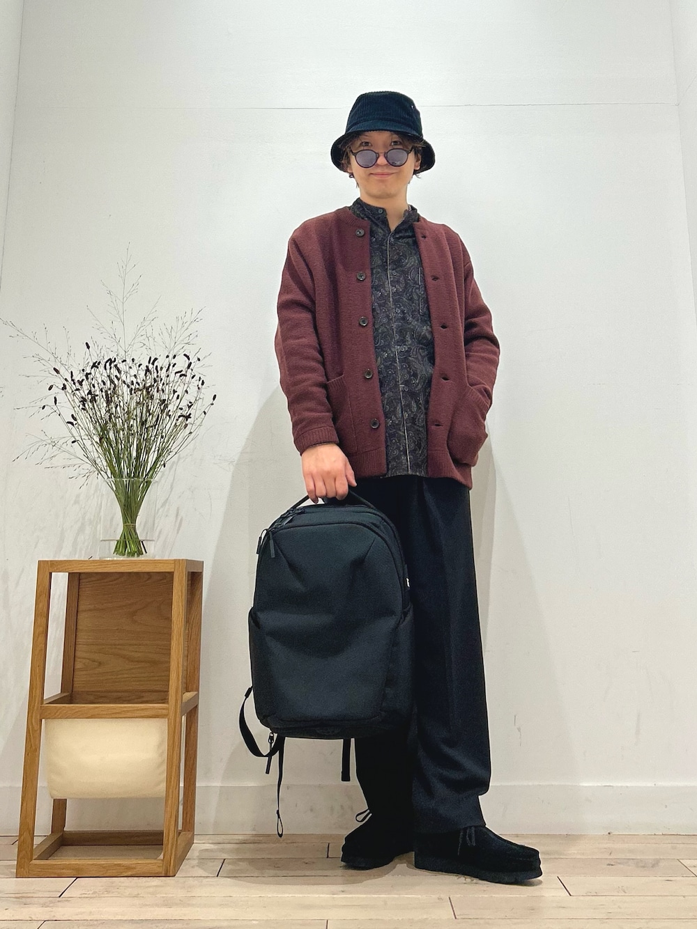 レッド系のカーディガン/ボレロ、ブラウン系のシャツ/ブラウス、ブラック系のスラックスを着用したメンズの秋コーディネートの1枚目の写真