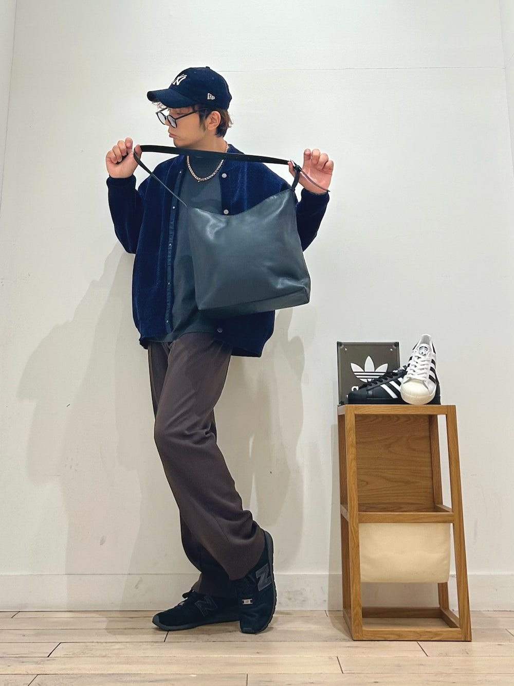 ホワイト系のスニーカー、ブラック系のショルダーバッグ、ブラウン系のその他パンツを着用したメンズの秋コーディネートの1枚目の写真