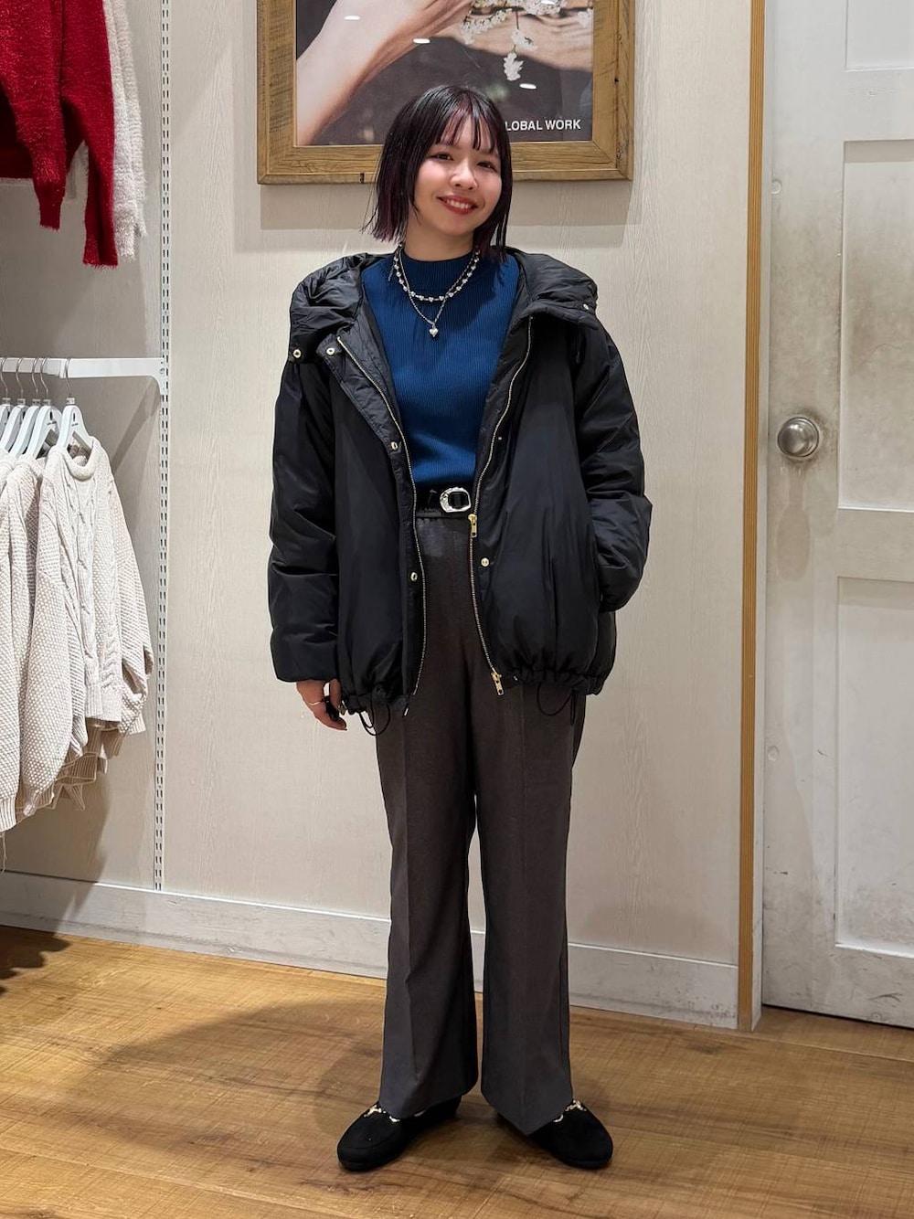 ブラック系のダウンジャケット/コート、ブルー系のニット/セーター、グレー系のその他パンツを着用したレディースの冬コーディネートの1枚目の写真