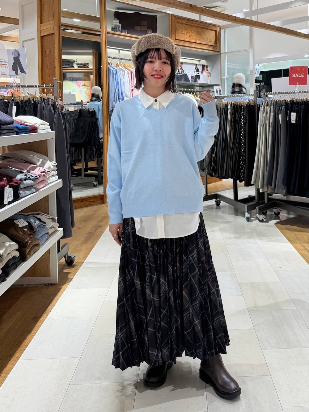 ホワイト系のシャツ/ブラウス、ブラウン系のブーツ、ブルー系のニット/セーターを着用したレディースの冬コーディネートの1枚目の写真