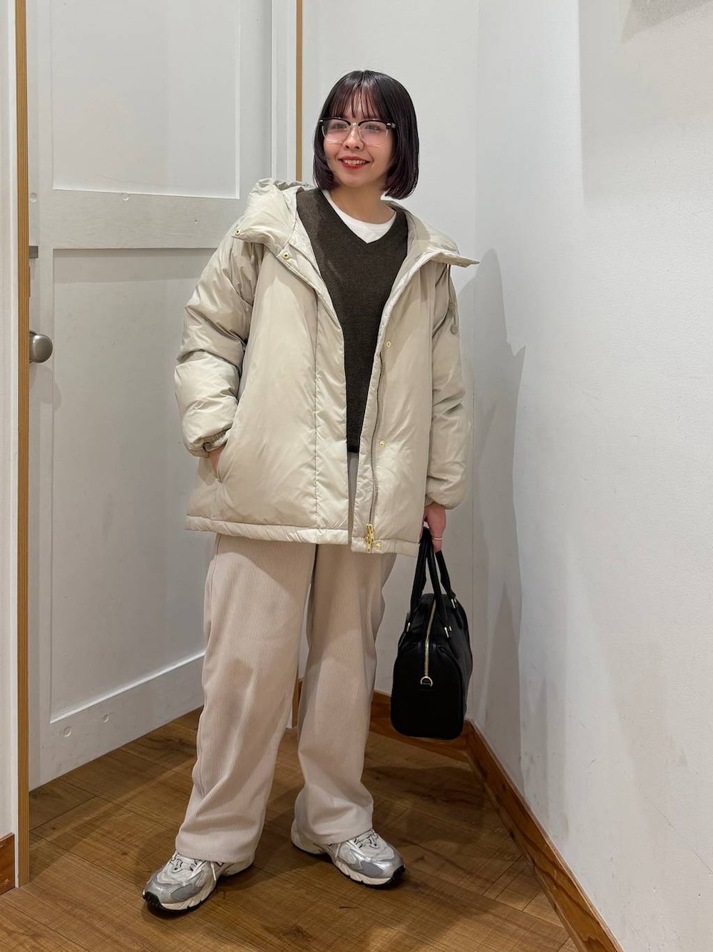 ベージュ系のダウンジャケット/コート、グレー系のその他パンツ、ホワイト系のTシャツ/カットソーを着用したレディースの冬コーディネートの1枚目の写真