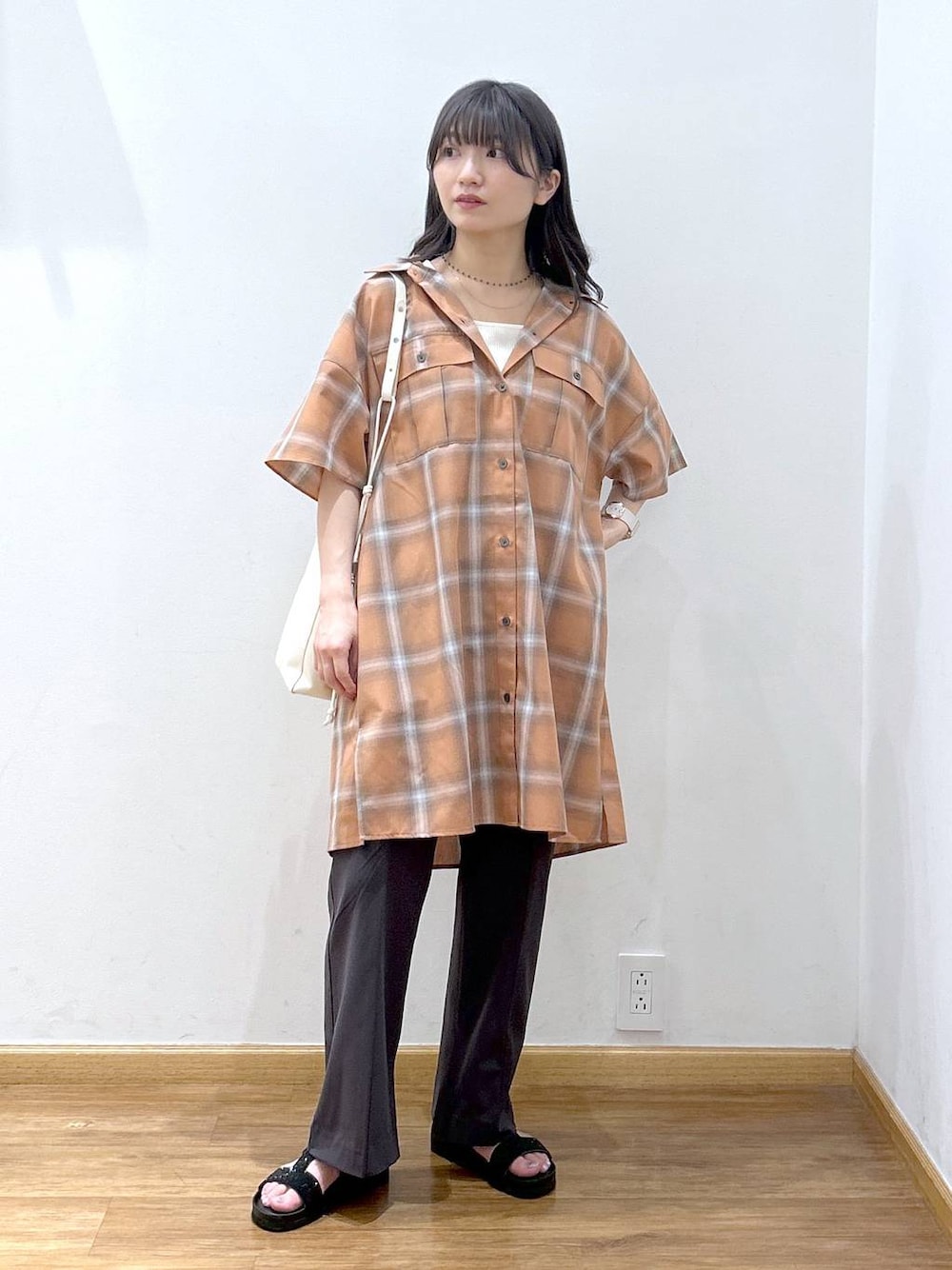 ホワイト系のタンクトップ、オレンジ系のワンピース、ホワイト系のショルダーバッグを着用したレディースの夏コーディネートの1枚目の写真