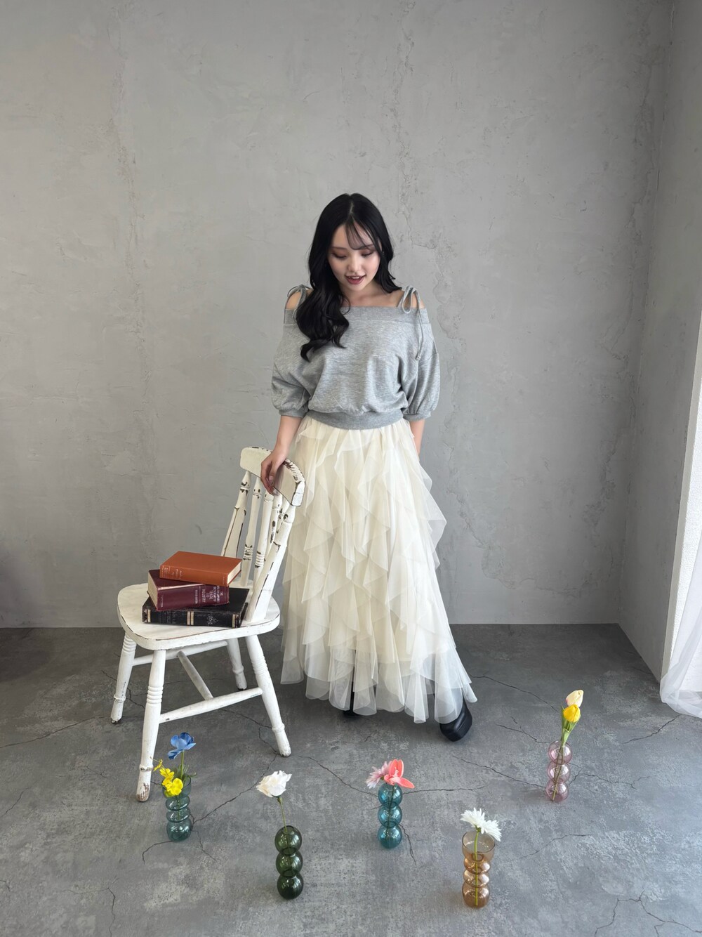 グレー系のスウェット、ホワイト系のスカートを着用したレディースの春コーディネートの1枚目の写真