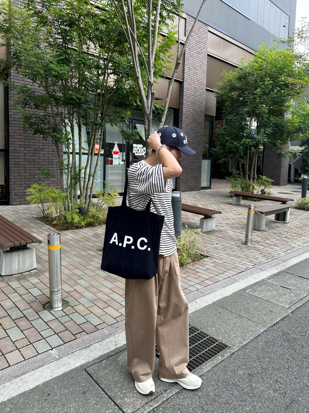 ブルー系のトートバッグ、ホワイト系のTシャツ/カットソー、ベージュ系のその他パンツを着用したメンズの秋コーディネートの1枚目の写真