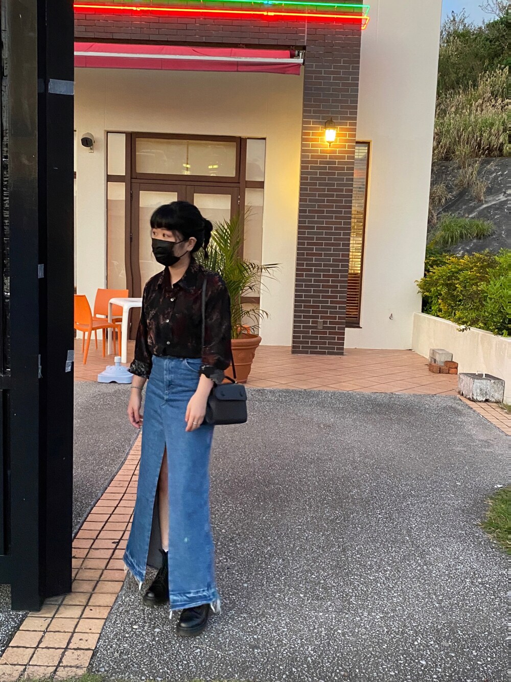 ブラック系のシャツ/ブラウス、その他のデニムスカート、ブラック系のブーツを着用したレディースの春コーディネートの1枚目の写真