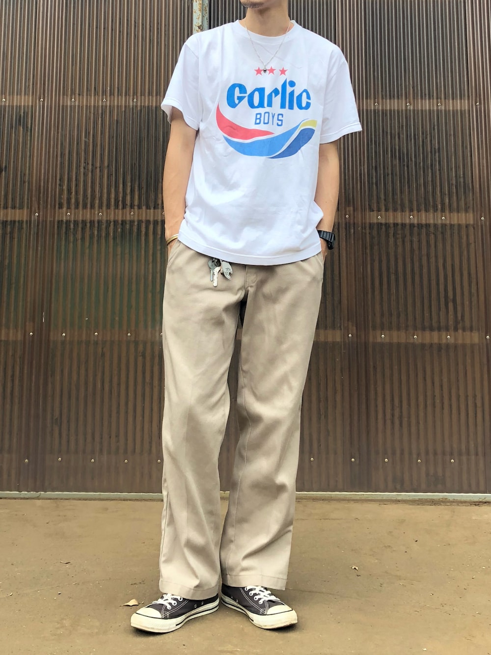 ベージュ系のチノパンツ、ブラック系のスニーカー、ホワイト系のTシャツ/カットソーを着用したメンズの夏コーディネートの1枚目の写真