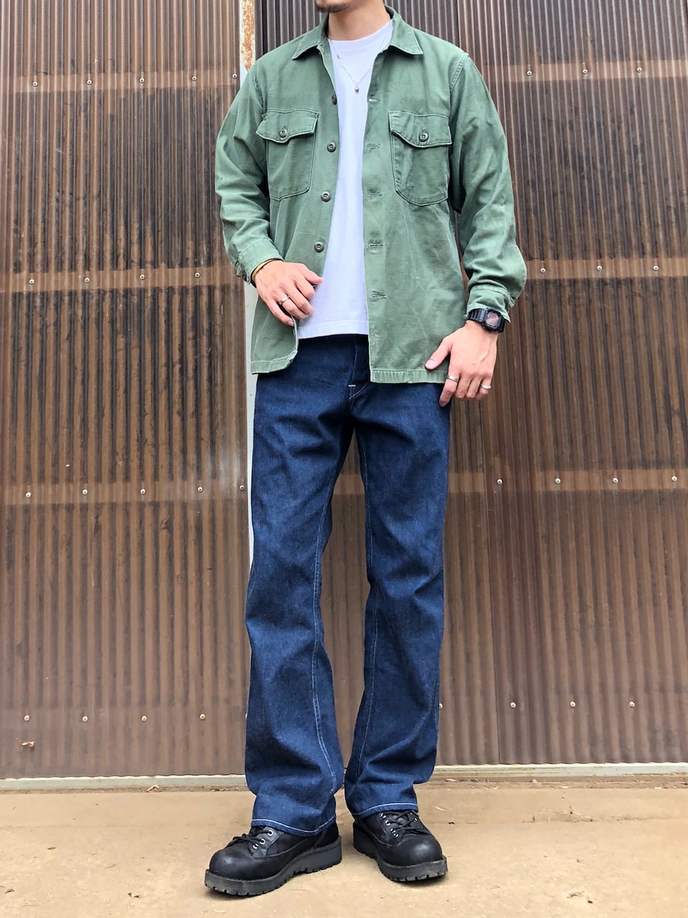 グリーン系のシャツ/ブラウス、ブルー系のデニムパンツ、ブラック系のブーツを着用したメンズの秋コーディネートの1枚目の写真