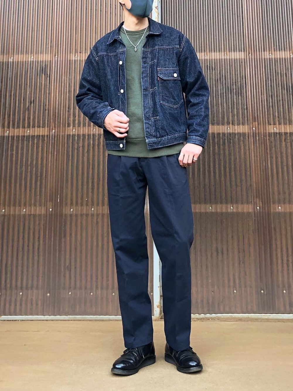 グリーン系のスウェット、ブルー系のデニムジャケット、ブルー系のスラックスを着用したメンズの秋コーディネートの1枚目の写真