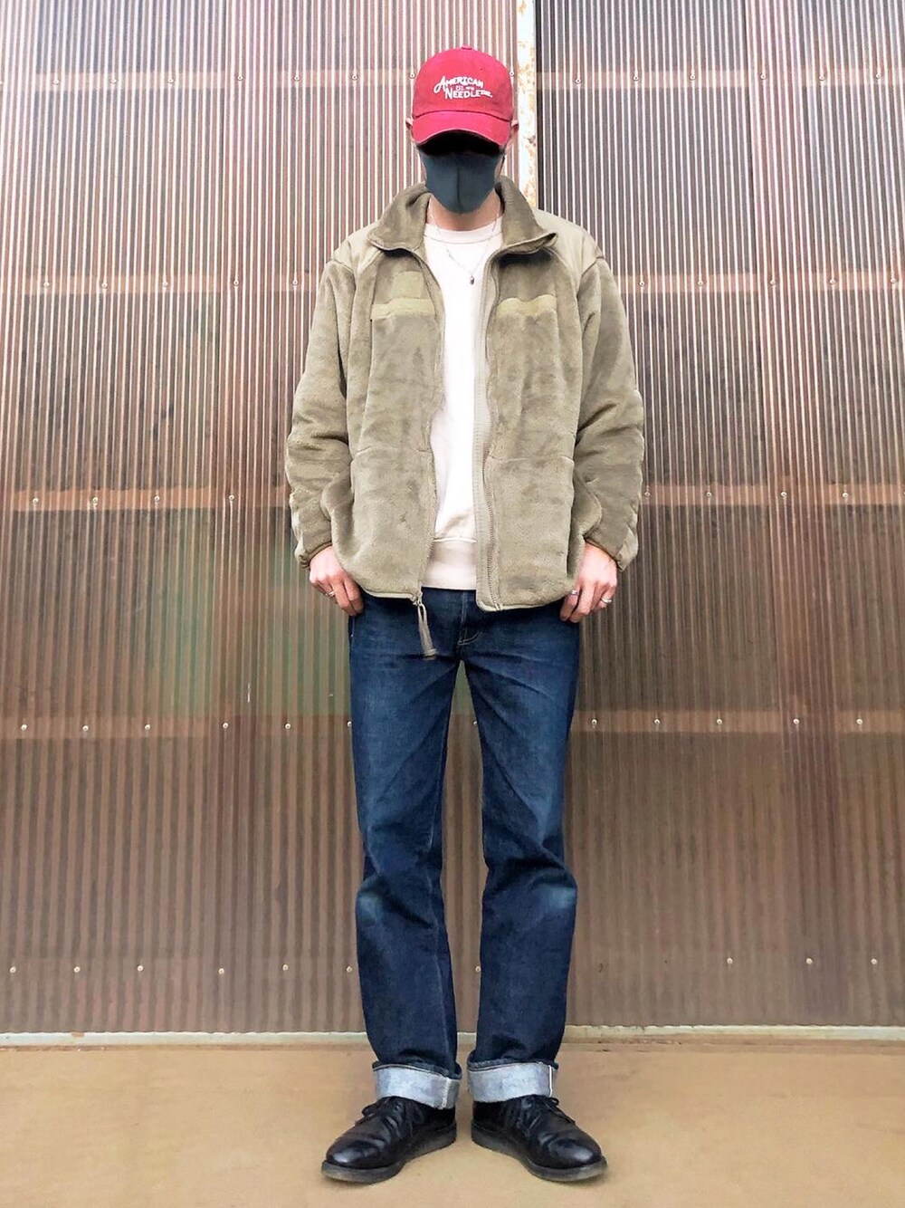 ベージュ系のミリタリージャケット、ベージュ系のスウェット、ブルー系のデニムパンツを着用したメンズの秋コーディネートの1枚目の写真
