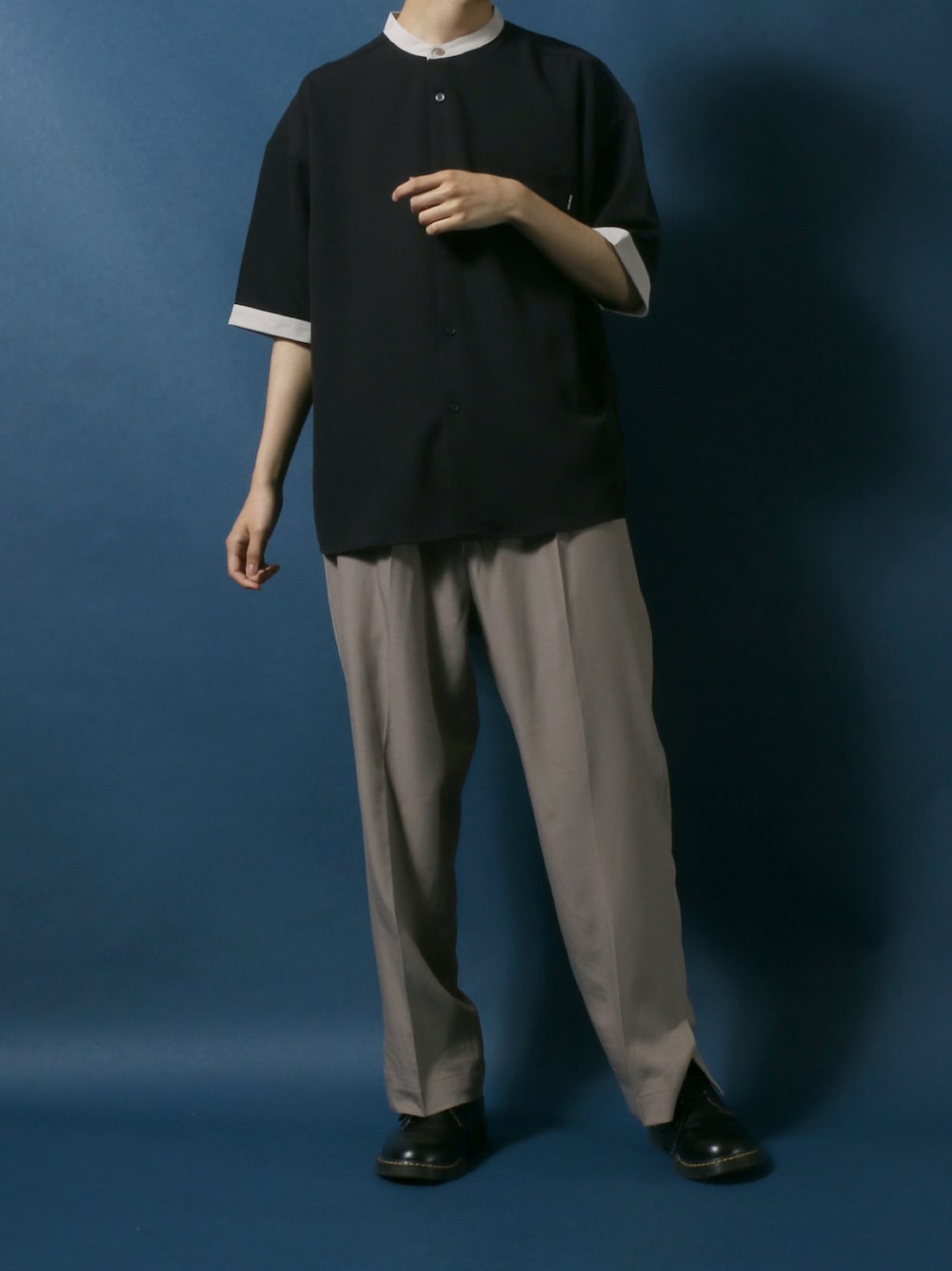 ブラック系のシャツ/ブラウス、ベージュ系のスラックス、ブラック系のドレスシューズを着用したメンズの春コーディネートの1枚目の写真