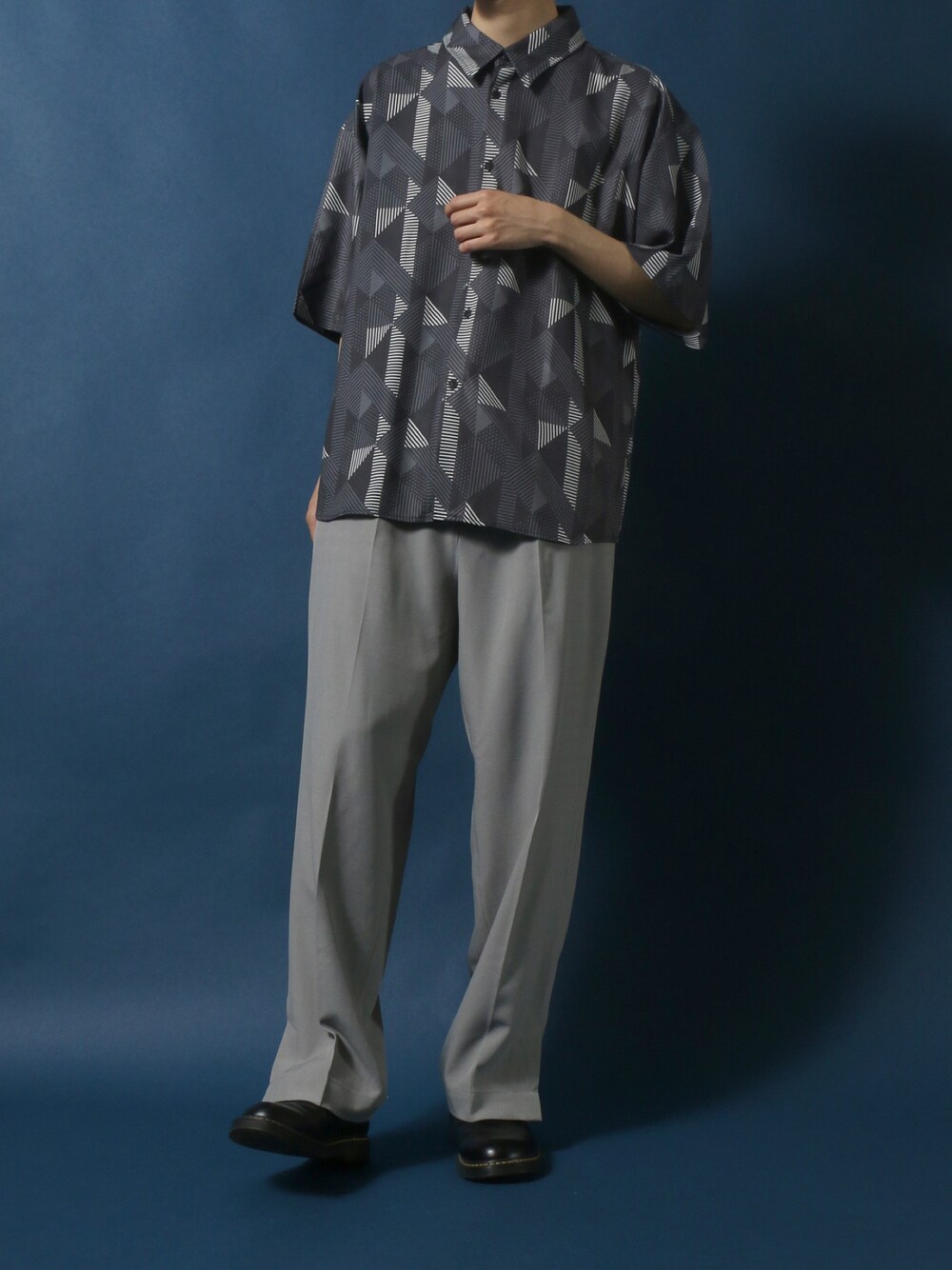 グレー系のシャツ/ブラウス、グレー系のスラックス、ブラック系のドレスシューズを着用したメンズの春コーディネートの1枚目の写真