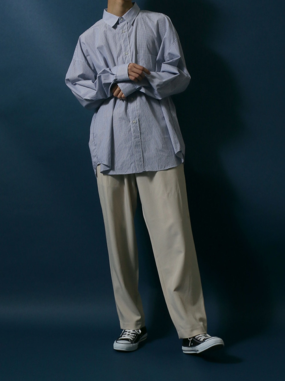 ブルー系のシャツ/ブラウス、ベージュ系のスラックス、ブラック系のスニーカーを着用したメンズの春コーディネートの1枚目の写真